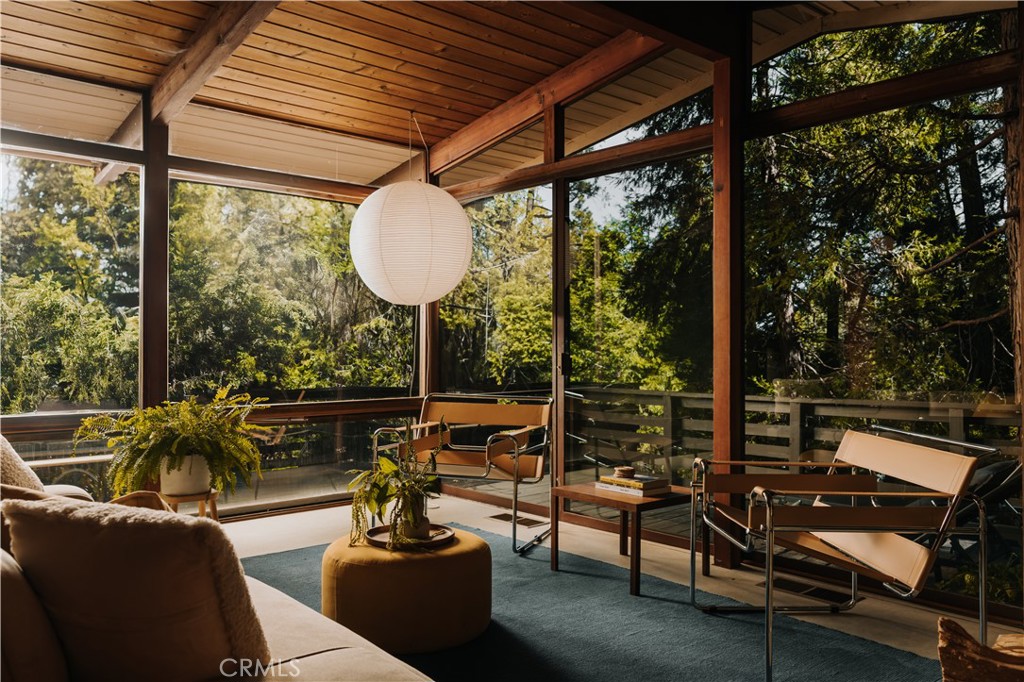 Mid-Century Holiday Retreat in the Pines – San Moritz, Crestline A rare opportunity to own a true mid-century gem tucked among the towering pines of Crestline’s sought-after San Moritz neighborhood. Built in 1956 and thoughtfully updated, this architecturally distinct cabin blends classic design with modern sophistication—creating a retreat that feels both timeless and luxurious. Set back from the road on a generous, tree-filled lot, the home’s open-concept interior is bathed in natural light through floor-to-ceiling windows that span two walls, blurring the line between indoors and out. The surrounding forest becomes a living backdrop, creating the serene sensation of being immersed in nature—even while inside. The original stone fireplace anchors the living space, while the spacious deck extends the experience outdoors, perfect for entertaining or quiet mornings among the trees. Every detail has been carefully curated—from eco-friendly Marmoleum flooring and updated electrical with a new panel to a brand-new central heating and air system. Smart features include a Nest thermostat and Ring security system for effortless comfort and peace of mind. Two beautifully appointed bedrooms and a versatile bonus room provide space for guests, a home office, or creative pursuits. Located just three minutes from Lake Gregory and moments from Crestline Village shops and dining, with Lake Arrowhead only 14 minutes away and Los Angeles under 90 minutes, this property offers an ideal balance of privacy and accessibility. A proven 5-star Airbnb, the home is offered fully turnkey with designer furnishings—ready to enjoy immediately as a refined mountain retreat, vacation rental, or full-time residence.