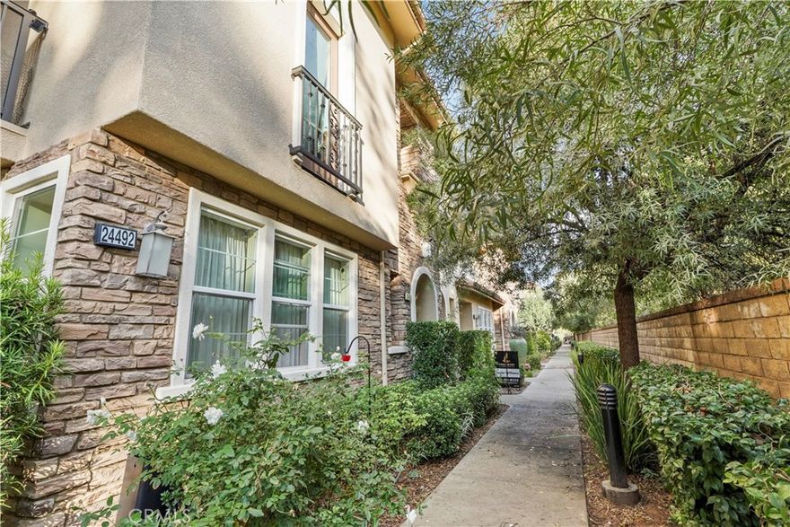 Welcome to this beautifully maintained townhome in the highly sought-after West Creek community of Valencia. Nestled along a peaceful, tree-lined walkway, this inviting residence offers comfort, privacy, and a wonderfully functional floor plan. Step inside to a bright, open living area featuring rich wood-style flooring, abundant natural light, and flexible space for both living and dining. The adjacent kitchen includes granite countertops, generous cabinet storage, and sleek black appliances—ideal for home cooks and entertainers alike. Upstairs, the spacious primary suite features a large walk-in closet and en-suite bath. Additional bedrooms offer excellent versatility for guests, home office, or family. Enjoy outdoor living on your private balcony with views of the surrounding hills. This home also includes an attached direct-access garage with fresh epoxy painted floors and convenient indoor laundry. The West Creek community features scenic walking paths, lush landscaping, and access to top-rated schools, shopping, dining, parks, pools, and clubhouse amenities. Move-in ready and perfectly located—this is Valencia living at its best. This home is available with Owner Financing and Lease to Own Option Terms. If interested, please contact listing agent!!!