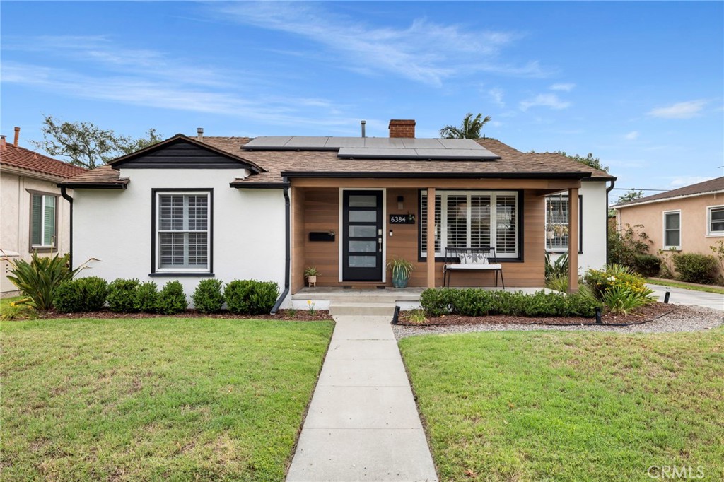 Welcome to 6384 Lewis Ave, a beautifully updated home that blends warmth, charm, and modern convenience in Long Beach. From the moment you arrive, the curb appeal stands out with clean landscaping and eye-catching redwood plank paneling that adds a modern twist to the classic front porch. Step inside to discover rich wood floors and an inviting living area centered around a decorative fireplace, perfect for cozy nights in or stylish entertaining. The open layout flows into a dining area with a built-in banquette that maximizes both space and style. Just beyond, the kitchen shines with a fresh, designer feel, featuring a striking royal blue and white color palette, medallion-patterned tile backsplash, stainless steel appliances, and a breakfast bar ideal for your morning coffee or casual bites with friends.
This home offers three well-appointed bedrooms, a tastefully updated full bathroom, and a bonus enclosed patio addition that serves as a flexible second living space, currently styled as a family room with dedicated laundry area. Step out back and enjoy a spacious yard with plenty of room to relax or entertain. There's a paved patio for al fresco dining, a grassy area for play or pets, citrus trees for a fresh pop of flavor, and a fire pit zone that’s ready for weekend gatherings.
Other highlights include a detached 2-car garage, energy-efficient solar panels, and thoughtful plumbing, electrical and HVAC upgrades throughout. Whether you're hosting, relaxing, or growing into your next chapter, this is a home that fits your lifestyle. Don't miss the opportunity to make 6384 Lewis Ave yours.