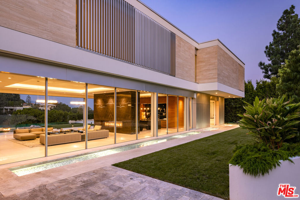 Extraordinary Estate by London-based Quinn Architects is a True Embodiment of Modern Luxury! Designed to impress, the home offers approximately 14,438 square feet of meticulously curated living space with floor-to-ceiling glass walls that showcase breathtaking panoramic views, set on nearly an acre of prime Lower Bel-Air real estate. The residence features an array of high-end amenities, including a grand glass atrium, expansive living areas, a chef's kitchen and an additional secondary prep kitchen. The main level provides a seamless flow between indoor and outdoor spaces, perfect for both intimate gatherings and large-scale entertaining. The upper level is dedicated to a sumptuous master suite, spanning around 2,100 square feet including a large private terrace complete with a spa and fire pit, and stunning views of the Bel-Air Country Club and city lights. The lower level is designed for ultimate relaxation and entertainment, featuring a game lounge with a bar, a state-of-the-art gym, a movie theater, and a temperature-controlled wine cellar. Additionally, the estate includes four spacious guest suites, a staff suite, and numerous outdoor amenities. The property is completed by a 65-foot infinity-edge pool, lush lawns, and ample patio spaces that extend the living area outdoors. This estate is a blend of contemporary elegance and sophisticated design. Truly a paragon of luxurious living in one of the most coveted locations in Lower Bel-Air. $11M down with an assumable bank loan of $22M at 3.85% for three years.