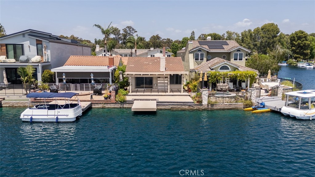 Positioned along one of the widest and most coveted stretches of the main channel, this home is part of a rare collection of lakeside residences that enjoy an uninterrupted, panoramic perspective of the water. At once understated and refined, the home’s interiors are anchored by a considered, open layout that seamlessly connects its four bedrooms and two bathrooms with a central gathering space. Here, the great room acts as the heart of the home, where living, dining, and kitchen zones coexist beneath vaulted ceilings and natural light. The kitchen serves as both a culinary hub and a point of connection, its placement thoughtfully designed to invite interaction while maintaining visual flow to the outdoors. Beyond, the experience of lakefront living is fully realized with a private dock capable of mooring a 16-foot Duffy, offering an ideal setting for quiet reflection or casual entertaining on the water’s edge. Complementing the home’s private comforts are the exceptional amenities of the surrounding community. A short stroll or boat ride leads to the residents-only clubhouse, where resort-like offerings include multiple pools, a spa, tennis and pickleball courts, indoor gym, and an array of sporting facilities. More than just a residence, this is a retreat defined by its connection to water, its sense of place, and the lifestyle it affords.