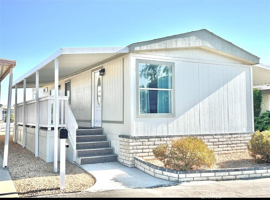 Move in ready home located in a peaceful 55+ community. This light filled, beautiful maintained 2-bedroom, 1 bath home manufactured home offers an inviting open concept layout with fresh flooring and abundant natural light throughout. The kitchen features ample cabinetry, a breakfast bar, and generous counter space. Both bedrooms provide confortable space and spacious closets. Additional highlights include a new water heater, upgraded finishes and a convenient in unit laundry area. The exterior offers a long-covered carport and low maintenance outdoor space that supports simple, easy living. A great option for those seeking comfort, convenience, and modernized features in a well-kept community.