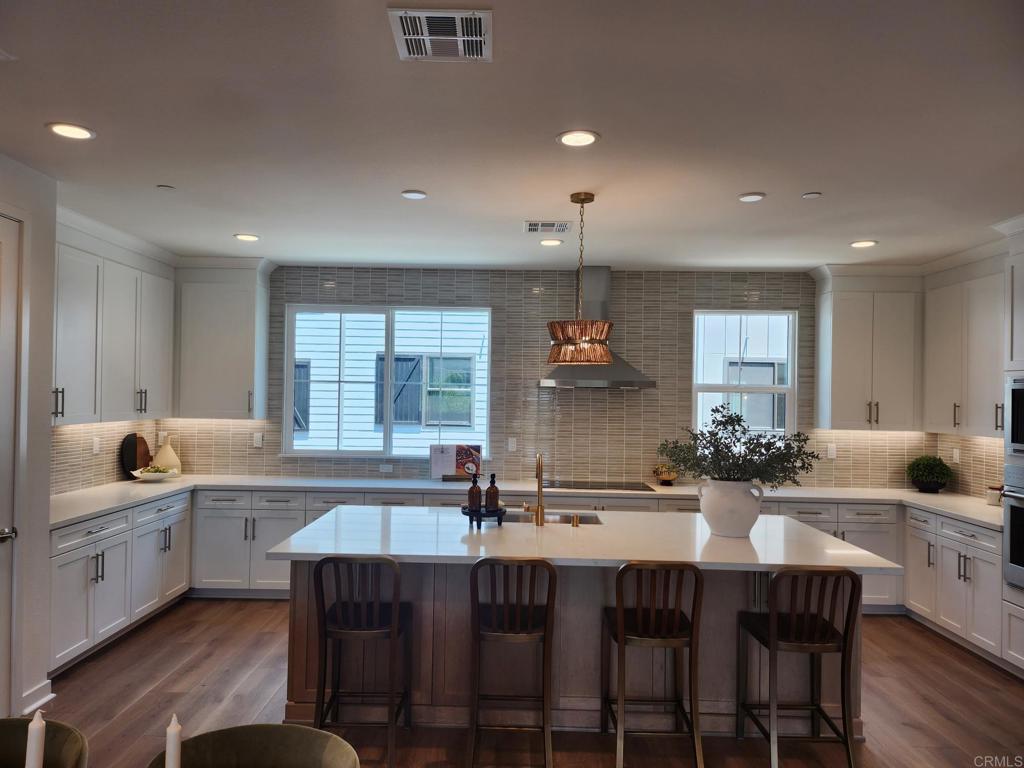 Discover contemporary living at its finest in this impeccable, three-story home, which showcases an open floor plan with 9-ft. ceilings and luxury vinyl plank flooring. Upstairs, the kitchen boasts a walk-in pantry, stylish island, Shaker-style cabinets, quartz countertops and top-of-the-line Wolf® and Cove® stainless steel appliances. Unwind in the third-floor primary bedroom, which features plush carpeting, a walk-in closet and connecting bath that offers cultured marble countertops, a walk-in shower and ceramic tile flooring. Enjoy outdoor living on the balcony. Additional highlights include a solar energy system, LED lighting, electric charging station and smart thermostat. Live effortlessly in this all-electric haven.