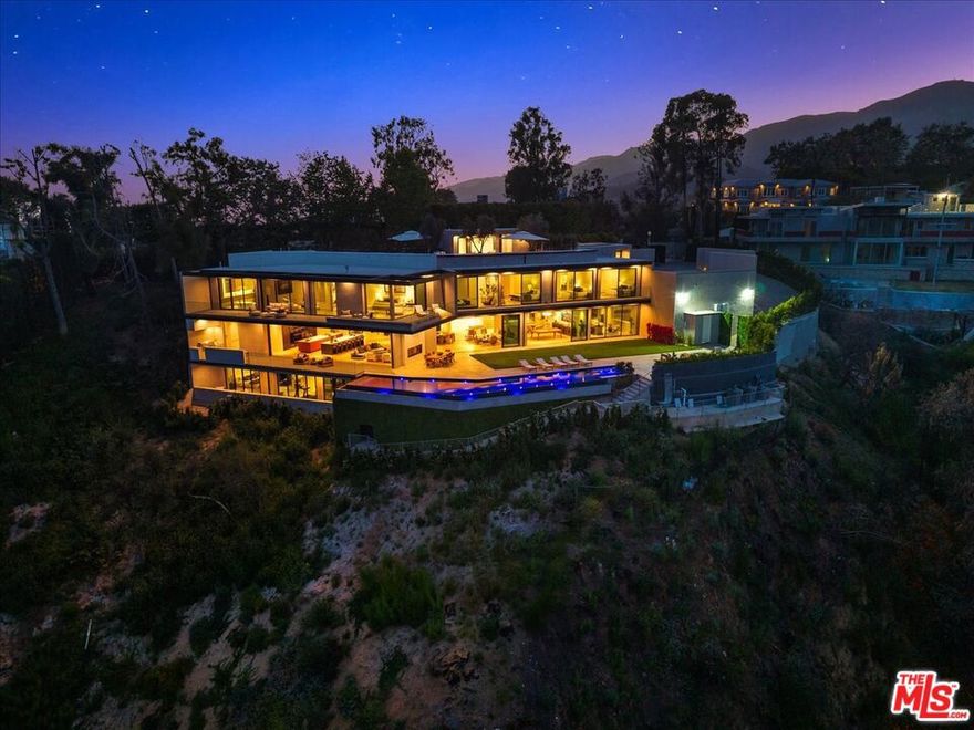 Set above Los Leones Canyon in Pacific Palisades with unobstructed views from the San Gabriel Mountains, Downtown LA to the Pacific Ocean. 766 Paseo Miramar presents a one-of-a-kind estate that balances architectural brilliance with sophisticated interior design. Spanning over 18,000 square feet with six all-ensuite bedrooms on an expansive 47,000-square-foot lot, this magnificent residence was meticulously designed by the renowned architect Tom Leishman with interiors by  Michael Palumbo and constructed by the dynamic GME Development. Fully furnished, this home showcases an exquisite collection of custom-designed and imported finishes from Milan's most esteemed houses, including Molteni, Poliform, Modulnova, Misuraemme, Porada, Gallotti, Bisazza, Rugiano, CEA, Lapalma, Flos, and Vismara, to name a few. Even Herms Milan contributed to this estate's refined aesthetic, providing select interior finishes and the elegant powder room mirrors. The curated art collection, featuring works by Paul Gruner and Accardi, was thoughtfully chosen to complement the home's grandeur. Among this estate's many standout features is a divine Poliform kitchen, which encompasses a dedicated chef's kitchen primed for easy, elegant hosting. Throughout the residence, Venetian plaster adds a unique and luxurious touch, enhancing the elevated ambiance.  This extraordinary estate boasts eight distinct HVAC zones, ensuring optimal comfort in every corner. A dedicated wellness center offers a sanctuary for rejuvenation, complete with a plunge pool, spa, and sauna, alongside a comprehensive private gym. A breathtaking primary suite spans over 2,500 square feet and features bespoke dual closets exquisitely designed and built by Molteni Milan. For the oenophile, a temperature-controlled wine cellar and an inviting bar create the perfect setting for entertaining. Also for entertaining, the expansive rooftop deck and the lower level ballroom which can be utilized for high-end private events.  Outside, find a dramatic 90-foot infinity boomerang pool with an integrated spa that seemingly melts into the horizon, and far-reaching vistas that capture the surrounding canyons and coastline beyond. These are, without a doubt, some of the area's most spectacular, unobstructed views.  Rooted in resilience, 766 Paseo Miramar remained intact through the fires that impacted the area. Completed in 2025, this estate presents an opportunity to own in a place shaped by both beauty and resilience.
