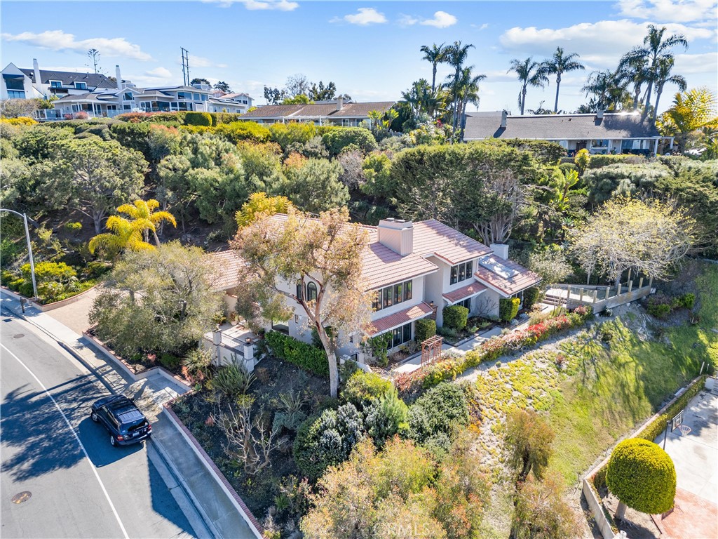 Experience refined coastal living in this stunning 5-bedroom, 4-bath, 3,868 sq. ft. custom residence in Mariners Point. Set on over ¾ of an acre, this exceptional home offers sweeping views of the ocean, coastline, sunsets, and Catalina Island—an unforgettable backdrop for everyday living.
Enter through a charming courtyard into a residence defined by timeless design and expert craftsmanship. Nestled against a natural hillside, the serene backyard evokes a mountain escape, bordered by lush landscaping and mature pine trees. The heart of the home is the chef’s kitchen, outfitted with premium Thermador appliances, a 6-burner range, and a stylish serving pantry. Just beyond, an expansive tiger eye wood deck showcases breathtaking ocean views—an entertainer’s dream. Mediterranean influences pair beautifully with modern sophistication: arched windows, double Dutch doors, and three fireplaces bring warmth and character. The spacious family room impresses with vaulted wood beam ceilings, skylight, and a wet bar with a built-in beer tap—perfect for gatherings. The formal living room is anchored by a dramatic arched brick fireplace and stained-glass touches. Upstairs, the primary suite is a peaceful retreat with panoramic ocean views, a cozy fireplace, and a spa-like bath featuring a soaking tub, walk-in shower, dressing area, and large walk-in closet. A versatile downstairs suite provides flexibility for guests or multigenerational living, while a fifth bedroom with private balcony captures more stunning coastal vistas.The grounds are equally inviting with terraced patios, lush gardens, and multiple outdoor spaces for entertaining or unwinding. A beautifully finished three-car garage and generous storage enhance functionality. Located just minutes from San Clemente’s beaches and golf course—and with no HOA—this extraordinary home offers the perfect blend of privacy, luxury, and lifestyle.