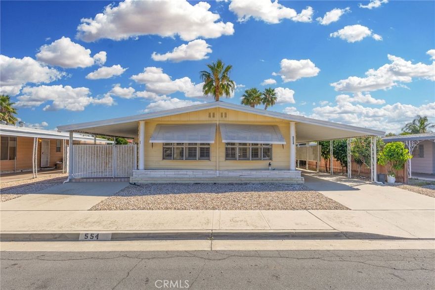 Welcome Home to Hemet! This beautiful home features one of the largest floor plans in the community, offering over 1,700 sq. ft. of comfortable living space. It includes 3 spacious bedrooms and 2 full baths, all complemented by very low property taxes. Step inside to find new flooring, newer plantation shutters, and a charming bar area perfect for entertaining. The exterior offers convenience and privacy with a carport that accommodates multiple cars and a gated side patio ideal for relaxing or hosting guests. Located just minutes from shopping centers, dining, and local amenities, this age-restricted community offers both comfort and convenience. Don’t miss the chance to make this wonderful home yours — it won’t last long!