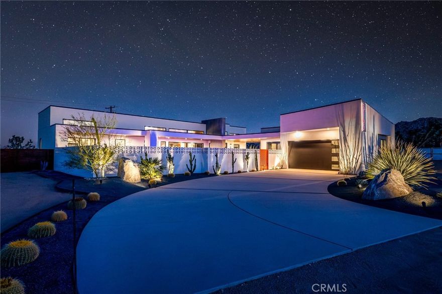 5165 Roy Rogers Road - Modern Desert Masterpiece. In the high desert, silence has texture, and light is its own architecture. At 5165 Roy Rogers Road, design and landscape move in harmony, a balance of modern form and natural stillness. Set on 1.26 acres in one of Pioneertown’s most sought-after settings, this three-bedroom, three-bath residence redefines desert modern living. The bold white-and-black façade, framed by a breeze-block courtyard and signature orange gate, makes an unforgettable first impression, both grounded and sculptural. Inside, expansive glass walls and polished concrete floors invite the desert light to play across every surface. The open-concept great room and designer kitchen merge seamlessly, featuring bespoke cabinetry, waterfall-edge stone counters, and refined mid-century influences that bring warmth to the clean architectural lines. Each bedroom suite offers its own sense of calm and privacy, designed for rest, reflection, and effortless connection to the landscape beyond. The home is offered fully furnished and turn-key, blending curated design with comfort and livability. Outdoors, the private courtyard unfolds around a sleek in-ground pool and spa, framed by native landscaping, sunlit terraces, and a covered outdoor kitchen crafted for year-round enjoyment beneath endless desert skies. Positioned in the heart of Pioneertown, just moments from its iconic gathering spots, Pappy & Harriet’s and the Red Dog Saloon, this residence captures the spirit of modern design framed by desert history. 5165 Roy Rogers Road, where Palm Springs polish meets High Desert soul. A modern architectural statement, ready to be lived in, shared, and remembered.