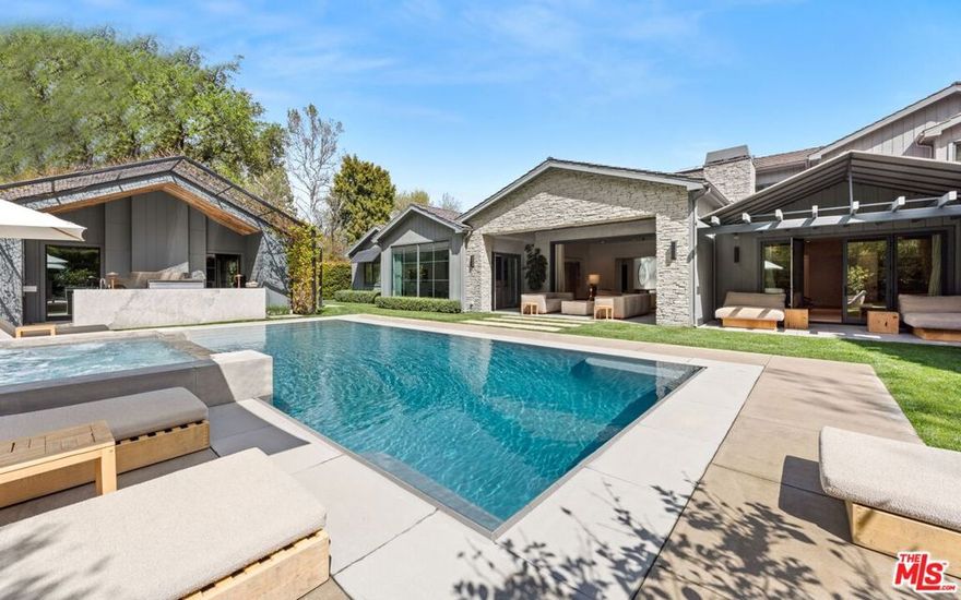 Custom-built celebrity compound designed by the legendary Waldo Fernandez. Situated amidst lush, mature trees on the most sought after street in Hidden Hills on a quiet cul-de-sac. The contemporary design features a bright and airy open floor plan with a stunning chef's kitchen boasting Wolf & Miele appliances, adjoining breakfast room with panoramic windows that showcase the picturesque landscape, and a large family room with a fireplace and high ceilings. All of the finishes have been custom curated from around the globe, including Walnut floors throughout, with all the latest and greatest amenities. The first-floor primary suite is a rare find, complete with an oversize custom closet and steam shower. Additional amenities include floating staircase, smart home system, gym, and custom home theater. Step outside to the impeccably landscaped grounds highlighted by a sparkling zero-edge pool, 10+ person spa, BBQ center, fire pit, and rolling lawns. Separate guest house offers bar, lounge area, and fireplace. Short distance to community tennis courts and pool. Experience the ultimate in luxury living in this custom-built compound designed by Waldo Fernandez, boasting stunning features and amenities throughout the luxurious property.