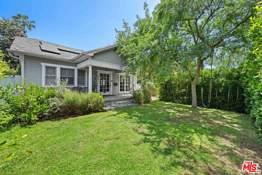 Located a stone's throw from vibrant Larchmont Village, this light-filled 3 bedroom, 2 bath bungalow with detached guest house is updated for modern living but retains classic bungalow style. A private hedged front yard and wide front porch welcome you. Inside, an inviting living room with fireplace leads to the dining room and French doors to a sunny porch and side yard. The chef's kitchen overlooks the back yard and features vaulted ceilings and a breakfast bar that opens to a cozy den. There's a spacious primary suite with private bath plus two additional bedrooms and a full hall bath. Out back, a dining pergola, grass yard and detached guest house with bath, a flexible space for visitors, home office, creative studio, or gym. Easy indoor-outdoor living just moments from shops, cafes, and everything Larchmont has to offer.