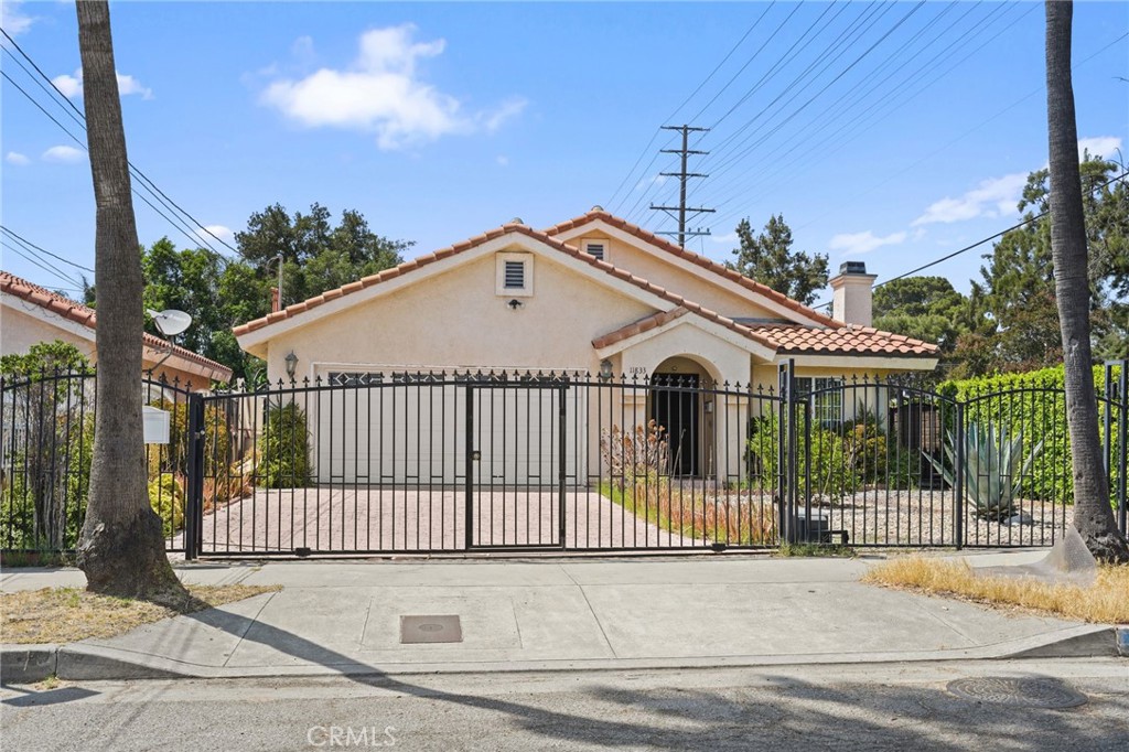 This well-maintained corner home, built in 2000 and securely gated, offers a functional and inviting layout with 4 bedrooms and 2 bathrooms. Step into a bright open living room featuring high ceilings, a cozy fireplace, and durable tile flooring that flows through the hallway and kitchen. All bedrooms are comfortably carpeted, including the spacious master suite, which features a large walk-in closet and a private bathroom with double sinks. The kitchen offers plenty of cabinet and countertop space, a pantry closet, and is conveniently located next to the dining area—ideal for family meals or entertaining. The 2-car garage offers direct access to the home and includes laundry hook-ups for added convenience. Outside, the low-maintenance front yard adds to the curb appeal, while the backyard features a covered patio, concrete area, a storage shed, and a side gate with room for additional parking or the potential to build a Jr. ADU. Additional highlights include paid-off solar panels, central AC/heat, double-pane windows, and a layout designed for comfort and functionality. Conveniently located near freeways, top-rated schools, shopping centers, restaurants, and parks, this home is the perfect blend of comfort, efficiency, and opportunity.
