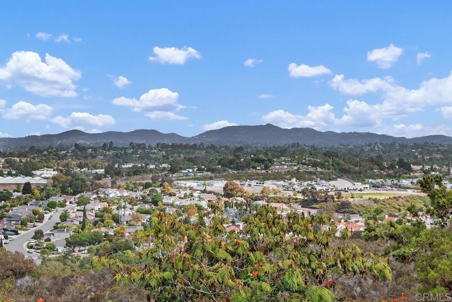 Perched at the end of a cul-de-sac in the gated community of Ocean Terrace, this Ocean Hills gem offers privacy, style, and sweeping 180-degree views from rolling hills to the Pacific Ocean. Soaring vaulted ceilings and expansive windows fill the living and dining rooms with natural light, while fresh paint, wide-plank LVP flooring, and multiple fireplaces create a warm, inviting feel. The kitchen features brand-new appliances, designer tile flooring, and a garden window framing stunning backyard views. A casual dining nook opens to the family room and outdoor spaces for seamless indoor-outdoor living. A first-floor bedroom and full bath are perfect for guests, a home office, or multigenerational living. Upstairs, the primary suite offers vaulted ceilings, a fireplace, and a private balcony with ocean and sunset views, plus a spacious bath with dual sinks, soaking tub, and two closets. The secondary suite also enjoys its own bath, walk-in closet, and balcony. Outdoors, the expansive backyard captures ocean, mountain, and sunset panoramas. Additional highlights include A/C, a two-car garage with laundry, a brand-new roof (2025), rebuilt primary balcony, and retractable awning. Ideally located near Melrose Dr. and Cannon Rd., this hilltop retreat offers coastal living just minutes from beaches, dining, and all that North County has to offer. Buyer and buyer’s agent to verify all in MLS prior to COE.