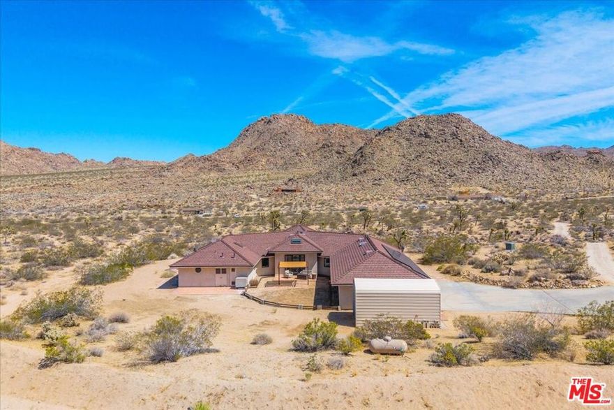 Desert Sanctuary: 16-Acre Private Estate in Joshua Tree. Nestled midway between Joshua Tree town and the west entrance to the National Park lies a rare offering: 16 fully-fenced acres of pristine desert landscape with complete privacy. The thoughtfully positioned 2,733 sq ft residence sits at the heart of the property, providing uninterrupted 360 views of the surrounding wilderness. The main house features 3 bedrooms and 2 baths, with the central living space defined by a striking hexagonal ceiling that draws natural light through strategically placed windows and skylights. A dramatic doorway opens directly to the landscape, blurring the boundary between interior comfort and desert beauty. The property offers practical amenities that enhance both work and leisure: a 4-car attached garage, additional detached storage, paid solar panels, and reliable connectivity via a private microwave internet tower and Starlink service. For guests or retreat space, an authentic hand-carved Mongolian yurt provides a luxurious glamping experience, complete with electricity, climate control, and custom furnishings. The outdoor living area includes a private bathroom with heated toilet seat, outdoor shower under the sky, and a cedar hot tub for stargazing. The landscape showcases more than100 Joshua trees among the Mojave's iconic flora - sculptural boulders and native plants create natural privacy, while providing habitat for desert wildlife. Residents regularly spot roadrunners, desert tortoises, coyotes, and soaring hawks across the property. This sanctuary offers the perfect balance: proximity to Joshua Tree National Park's wonders, yet secluded enough to provide true tranquility and connection with the desert's timeless beauty.