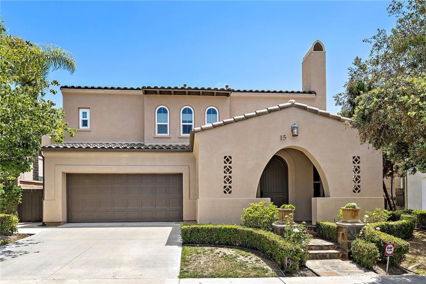 Discover refined coastal living in this beautifully upgraded home located in the tranquil San Lucar collection of Talega. This spacious 5-bedroom, 3.5-bathroom residence offers approximately 3,147 square feet of light-filled living space and sits on a private lot with no neighbors behind you—providing peace, privacy, and picturesque hillside views. Enjoy the charm of Spanish architecture combined with modern comforts. The thoughtfully designed floor plan includes a desirable main-level guest suite with a full bath and separate entrance—ideal for visitors, in-laws, or multi-generational living. Enter through a welcoming front porch into elegant living and family rooms, both featuring classic fireplaces, along with a formal dining room, powder room, and a gourmet kitchen that opens to the main living area. The chef’s kitchen is appointed with granite countertops, bright white cabinetry, a center island with bar seating, and professional-grade stainless steel appliances—perfect for entertaining or everyday living. Throughout the home, brand-new Milgard windows bring in abundant natural light while enhancing energy efficiency and style. New roll-up window coverings offer a clean, modern look with flexible light control and privacy. Upstairs, a spacious bonus room sits between three secondary bedrooms, a full bath, and the expansive owner’s suite. The primary suite serves as a private retreat with dual walk-in closets, spa-like soaking tub, oversized shower, and dual vanities. Stylish finishes include custom stone, ceramic and hardwood floors, recessed lighting, and French doors that accentuate the home’s bright and contemporary appeal. Outdoor living shines with a beautifully landscaped wraparound yard, front porch, and back patio—ideal for al fresco dining and relaxed evenings. Enjoy resort-style living just steps from Liberty Park, which features sports fields, courts, playgrounds, and picnic areas. Top-rated schools, scenic trails, golf, and San Clemente’s world-famous beaches are just minutes away.