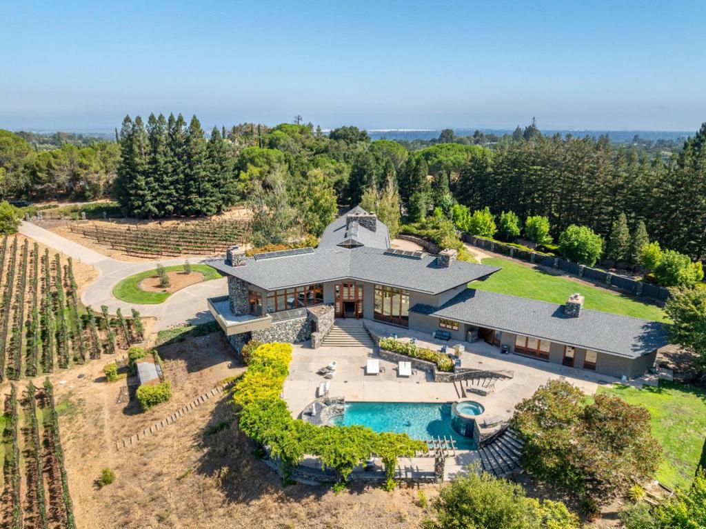 Contemporary Woodside. Designed by William A. Churchill and inspired by Frank Lloyd Wright - an extraordinary architectural masterpiece. One of the most sophisticated living and entertainment homes in Silicon Valley! Private, located on 3.38 gated acres, expansive entry is surrounded by a professionally managed vineyard of over an acre of Pinot Noir, Cabernet Sauvignon and Vermentino grape varietals. Open floor plan, 35-foot ceilings. The approximate 8,660 sq ft home has 5 bedrooms/ 6 full/2 half baths. Primary suite - stunning retreat w/fireplace, secluded outdoor terrace and dramatic ceiling.All bedrooms have unique features - ceilings of glass, views of the gardens and large adjoining bathrooms. Living room has views of the magnificent grounds and Santa Cruz Mountains. Five seat wet bar and game area. Library/office includes hand crafted bookcases and fireplace. Formal dining room. Openkitchen has granite counters and top of the line appliances.Family room.Outdoor entertainment area w/big western hill views, cascading pool and spa, verandas, barbecue and dining areas. Garden vegetable planters.Private spa/massage room, wet and dry saunas, gym room, and a private entry office w/kitchen and bath.Temperature-controlled wine cellar for 1,000 bottles, 4 car garage w/EV charger.