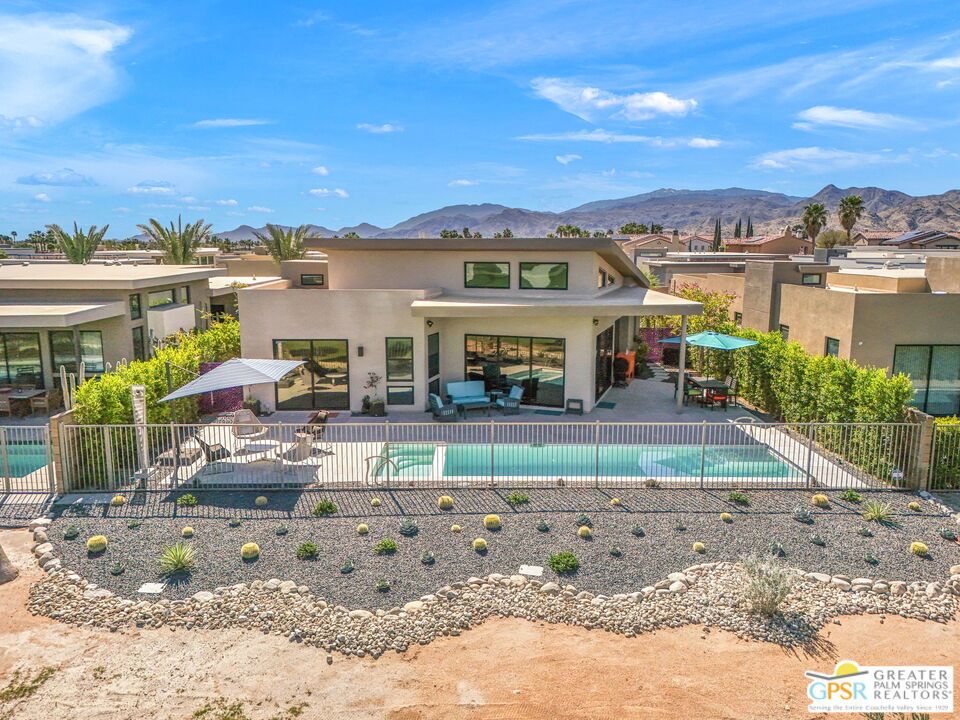 Located in the highly sought-after Escena Golf Club, this Fiore 3-bedroom, 3-bath, 2,593 sq ft home is a masterclass in contemporary design, comfort, and efficiency. Built in 2023 and elevated well beyond the builder's standard, this one-of-a-kind residence showcases custom upgrades, designer finishes, and bold artistic touches throughout. The open-concept layout features soaring ceilings, a showpiece kitchen with premium appliances, and a spacious great room framed by panoramic mountain and golf course views. Large sliders blur the lines between indoor and outdoor living, opening to a private west-facing patio with a sleek pool, the perfect sunset spot. Sustainability meets style with 18 owned solar panels and two battery storage backup systems, offering true peace of mind and energy efficiency year-round. The luxe primary suite, smart-home features, and low-maintenance desert landscaping add to the effortless lifestyle. Set behind the gates of Escena, enjoy access to a premier golf course, scenic walking paths, and a vibrant clubhouse with a renowned restaurant and bar just moments from your door.