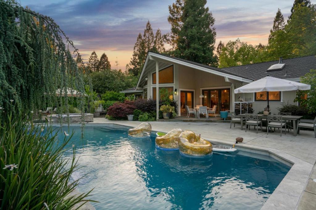 Welcome to a masterfully reimagined single-story estate in Blackhawks prestigious Hidden Oaks community. This extraordinary home blends timeless design with high-end craftsmanship and seamless indoor-outdoor living on a rare, flat 24,200 sq ft lot. Every inch of the 3,434 sq ft interior has been meticulously renovated with over $400,000 in luxury upgrades. Vaulted ceilings, newly refinished red oak floors, and two gas-burning fireplaces define the open, airy layout. The chefs kitchen features custom white cabinetry, quartzite countertops, high-end appliances, and an oversized island perfect for entertaining. The formal dining room and family room with a custom built-in desk offer style and function. The private primary suite includes a spa-inspired bath with freestanding tub, oversized shower, and walk-in closet. A junior suite with an added bathroom adds comfort for guests or multigenerational living. Outside, enjoy a solar-heated pool, spa, firepit, pergola, lush landscaping, and a detached 110 sq ft office with an AC. With a 3-car garage, new roof, new ducts/vents, and fresh designer paint, this home is move-in ready. Minutes from downtown Danville, Blackhawk Plaza, top-rated schools, trails, and commuter access.