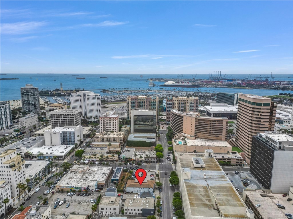 NEW PRICE IMPROVEMENT . . . Welcome to Unit 11 at 122 Elm Avenue—an exceptional opportunity to own a bright and stylish studio in the great pet friendly Grayson Arms condominium complex, perfectly located in Long Beach’s vibrant East Village Arts District. This second-floor unit is flooded with natural light, thanks to oversized windows offering views of both the lush courtyard and tree-lined street below.
Step inside to discover a thoughtfully designed layout featuring both a spacious walk-in closet and a mirrored sliding-door closet. The eat-in kitchen offers ample cabinetry and is complemented by tasteful updates throughout the home, including designer paint, modern plumbing fixtures, vertical blinds, recessed lighting, and a newer AC unit. Appliances include a new gas stove and refrigerator, along with a window AC and gas wall heater to keep you comfortable year-round. Community laundry is conveniently located on the first floor, and the courtyard features a BBQ area with outdoor dining. Rental parking is available at the adjacent lot and through Westin on a monthly basis.With a Walk Score of 97, you’re steps from the Metro Blue Line, Pine Ave, Shoreline Village, The Pike, Terrace Theater, and an array of trendy coffee shops, galleries, and restaurants. On-site laundry, low HOA dues, and a pet-friendly community make living here easy and enjoyable. Street parking is plentiful, and monthly spaces are available for rent at the adjacent Westin Hotel. Unit went under total remodeling with new appliances in 2024.