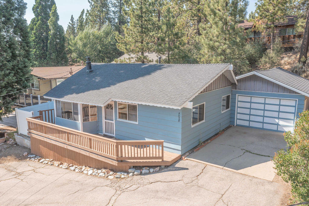 Prime Moonridge location with Ski Slope views! Conveniently located near the base of Bear Mountain Resort, the Big Bear Alpine Zoo, the golf course, and the Moonridge corridor, this home offers year-round appeal. Enjoy stunning ski slope views of both Snow Summit and Bear Mountain. Perfect as a short-term rental, second home, or full-time residence. Inside, you'll find a spacious single-level floor plan with vaulted open-beam ceilings in the living and dining areas, dual-pane windows, and an efficient wood-burning stove for cozy winter nights. The kitchen features charming knotty pine cabinetry, newer stainless-steel stove and refrigerator, built-in dishwasher, and plenty of storage. A separate laundry room adds convenience. Additional features include a two-car garage, fenced backyard with dog run, and furnishings included per seller's inventory (at no monetary value).