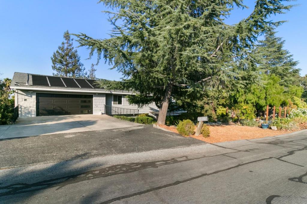 Set on an expansive ~17,300 sq. ft. lot, this serene property offers privacy, resort-style living, and sweeping Bay views. Highlights include a custom pool, ~1,400 sq. ft. redwood deck, and landscaped gardens for seamless indoor-outdoor living. The home features a striking Alaska pine entry door, a primary suite with walk-in closet and garden access, plus three additional bedrooms. Enjoy a bright kitchen, river rock fireplace, and a separate guest unit with private entrance. A custom-built theater and oversized garage with abundant storage complete this exceptional property. Additional highlights include fresh interior paint, an oversized garage with abundant storage, and extra guest parking. Conveniently close to Canyon shops, downtown Redwood City, scenic hiking trails, and open space preserves, this property truly combines comfort, elegance, and lifestyle.