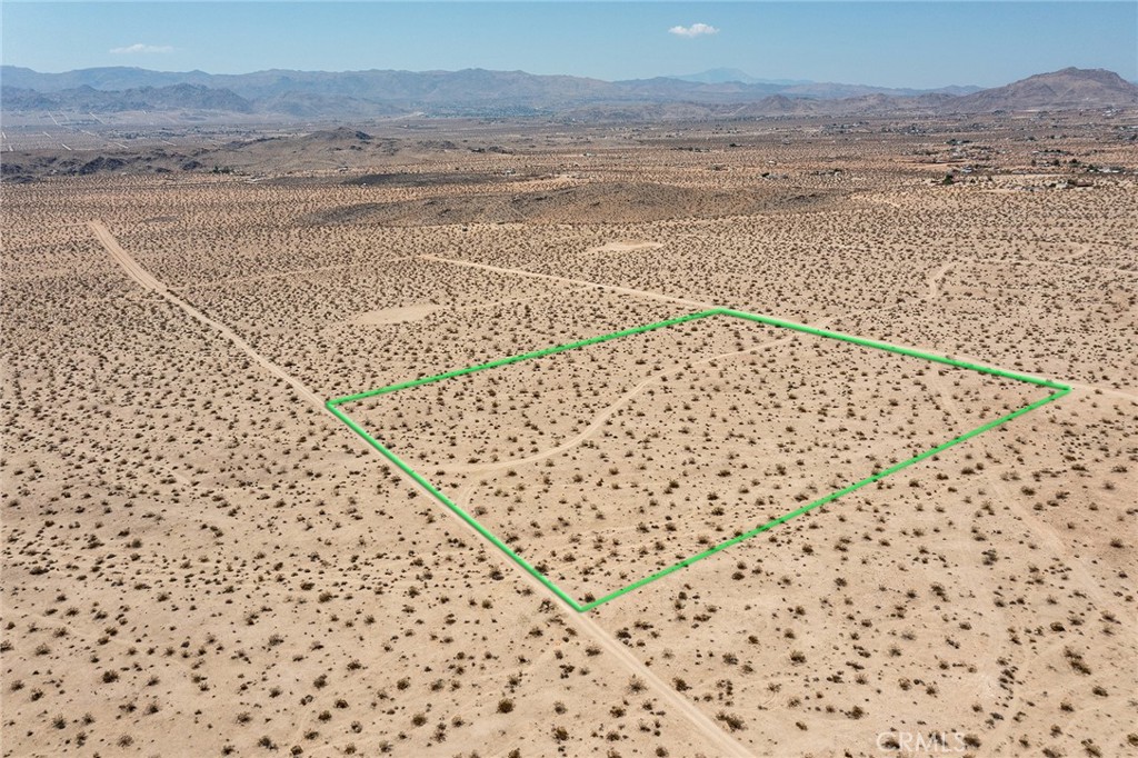10-ACRES: Surrounded by wilderness. Forever views. Mountains of Joshua Tree National Park to the south. Located on a mesa above the ancient dry lake bed below. NOTE: Green lines demarcating boundaries in pictures are approximate. APN: 0606-321-10