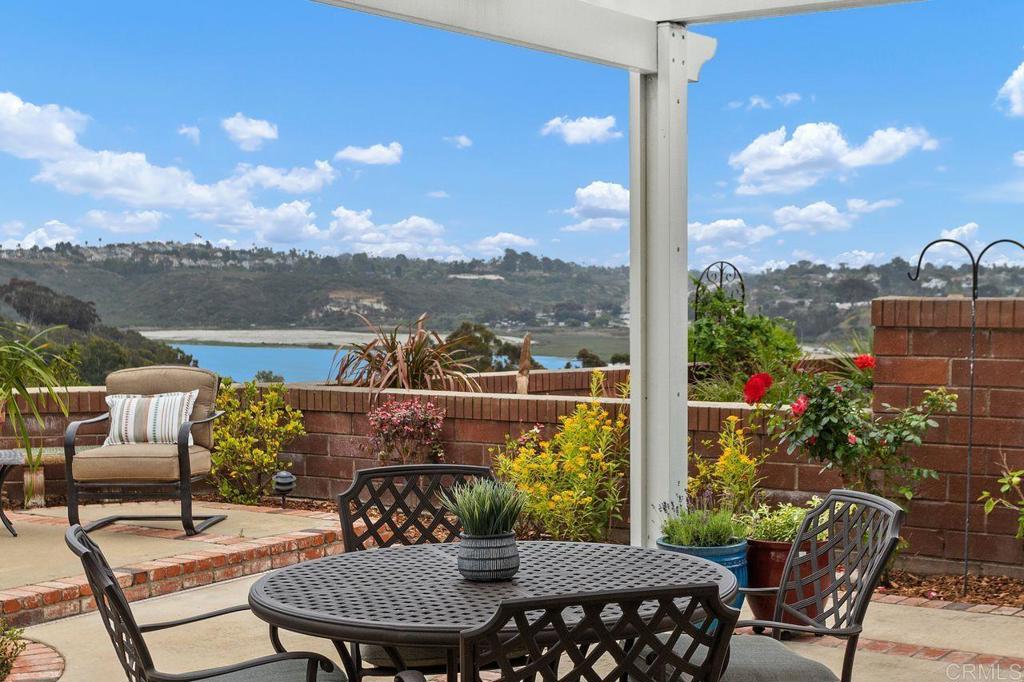 Nestled within the exclusive gated community of Sea Cliff, this stunning single-level home occupies one of the largest and most desirable premium view lots in the neighborhood. The property offers sweeping panoramic views of Batiquitos Lagoon and the surrounding coastal backcountry. The expansive lot has been thoughtfully designed as a private outdoor retreat, mature gardens and multiple patio spaces (gardener included 2 visits per month). Inside, vaulted ceilings and abundant natural light enhance a spacious, open-concept layout. This home features the highly sought-after “Cardiff C” floorplan—the largest single-level model in Sea Cliff—along with post-builder enhancements that add versatility and livability. The den has been enlarged and includes a custom built-in cabinetry, offering the perfect space for a home office or optional third bedroom. The second bedroom has been expanded into a generous suite with its own private patio, creating a welcoming space for guests or extended stays. The main living and dining areas are warm and inviting, centered around a cozy fireplace and framed by walls of windows that open to the surrounding patios. Both bathrooms have been beautifully remodeled, with one featuring a luxurious steam shower. As you pass through the private gates of Sea Cliff, you're welcomed into a community set across 14 acres of impeccably landscaped grounds. Scenic walking trails weave through ponds, lakes, and tranquil creeks. Resort-style amenities include two saltwater pools and spas, a fully equipped clubhouse, lighted tennis courts, and an entertainment pavilion. Located less than a mile from Ponto State Beach and moments from shopping, dining, and top-rated schools, this home offers the best of Southern California’s coastal lifestyle. Don’t miss this rare and remarkable opportunity to live in one of Carlsbad’s most desirable communities.