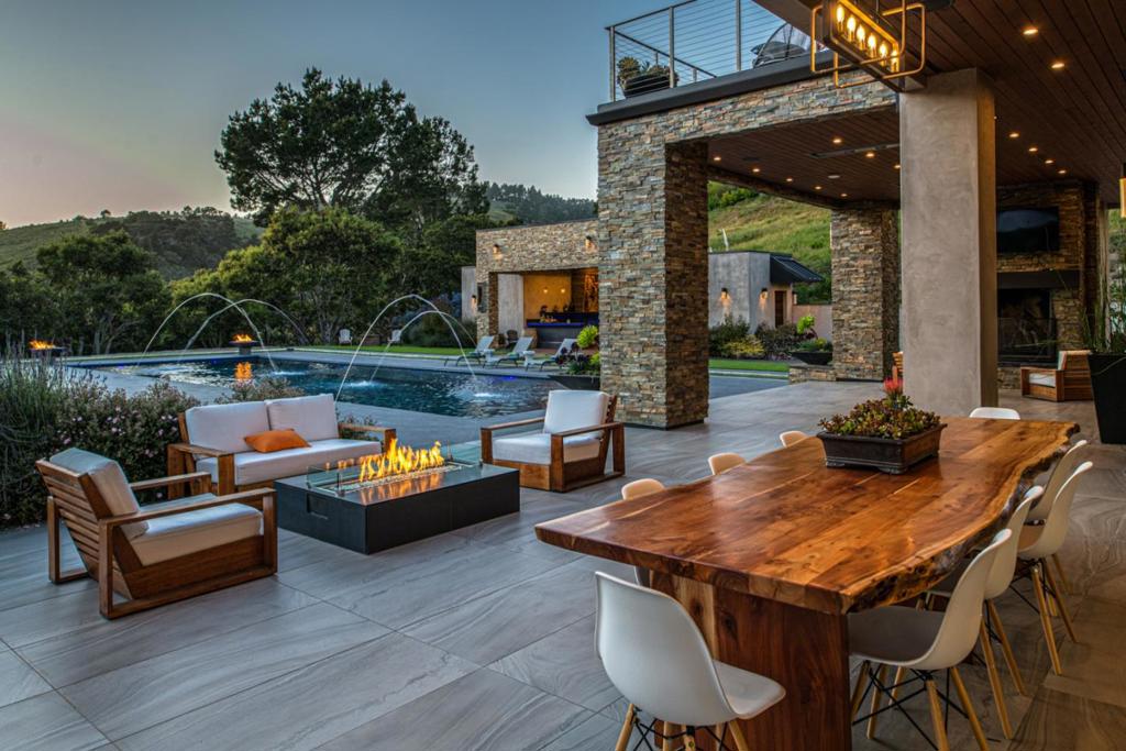 Located amongst the rolling hillsides of world-renowned Tehama Golf Club resides this 6-acre gated estate in Carmel Valley featuring stunning contemporary design and an impressive list of amenities. Through the front door you will note the large scale of the exterior matches the grandness of the interior. The open floor plan flows effortlessly between the living room, dining room, kitchen, and through to the luxurious pool house and outdoor kitchen equipped with BBQ and custom-built pizza oven. The oversized heated pool offers a stunning and private setting to entertain large groups and host events and the 2-bedroom guest house affords a separate retreat with full kitchen & bath. Car enthusiasts will also delight in the combined 9+ car garage space plus generous uncovered parking. Positioned just a couple minutes from the Carmel Valley gate with captivating views of the Santa Lucia mountains, sunny & serene Carmel Valley meets contemporary, luxurious living.