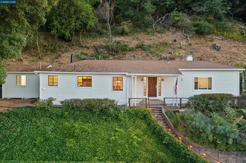 Perched on a private ridge above Orinda, this light-bathed single-level retreat serves up cinematic reservoir-to-golf-course views from sunrise to star-shine. Wrapped in fresh white siding, it welcomes with a rustic plank door into a living room clad in board-and-batten walls, warmed by hardwood floors and a stone fireplace beneath towering ceilings. The eat-in kitchen pairs stainless appliances with abundant counter space and ever-changing panoramas, plus direct access to the laundry room and a handy half bath. The serene primary bedroom boasts a flexible office/sitting nook; a second bedroom shares a full bath with soaking tub and separate shower. Step outside to an expansive view deck and terraced paths leading to a partially finished, un permitted ADU—ideal for studio, guest suite, or income potential—alongside a detached garage/workshop and ample parking. Quiet, secluded, and moments to downtown, BART, and top-rated schools, this hillside haven invites you to finish the dream. Welcome home!