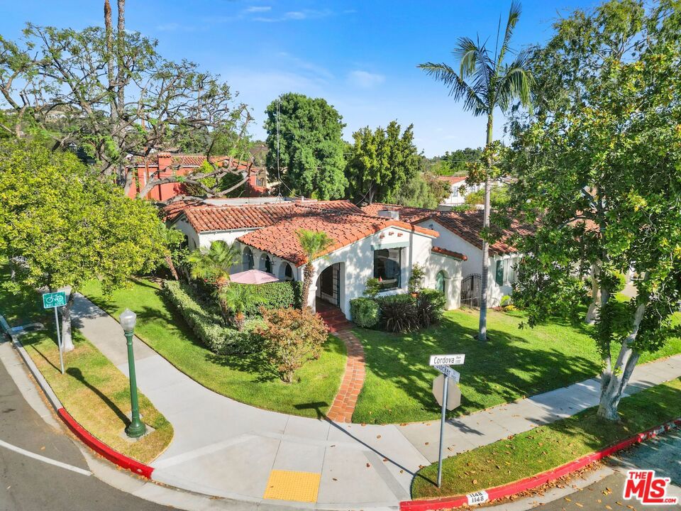 Set behind a classic arched courtyard with bougainvillea and a bubbling fountain, this 1931 Spanish Colonial Revival invites you into something special. Located in the heart of Glendale's coveted Rossmoyne Historic District, home to some of the most beautiful Spanish home in Glendale. This romantic home balances its deep architectural roots with thoughtful updates that honor its past. Step through the carved wooden door into a warm and inviting entry, where soft arches and a magnesite floor welcome you with quiet elegance. The living room is equally compelling as a step-down space with original French windows, a vaulted, beamed ceiling with hand-stenciled detailing, and a fireplace with handmade tiles crafted by the historic Markoff Mosaic Tile Corporation. Peg-and-groove hardwood floors extend through much of the home, adding richness and texture throughout. Opposite the living room, the dining room overlooking the courtyard fountain offers generous proportions creating an effortless flow that's sure to be the setting of many gatherings. The kitchen is bright and updated, blending seamlessly with the home's style and offering plenty of space for cooking and connection. Two full bathrooms have been restored in character with the home's era, including beautiful tilework that reflects its 1931 Spanish roots. Three bedrooms offer comfortable spaces including an en-suite bedroom that invites you to the veranda and backyard. Out back, the flagstone-paved yard surrounds the expansive spa tucked under twinkling lights and umbrellas, with beautiful stucco walls and mature greenery. The shaded veranda off the house offers a comfortable spot to relax or entertain, making the entire backyard feel like a private retreat, lush and serene. Additional updates include copper plumbing, newer central air and heat, and a bolted foundation. 1148 Cordova is a place where history feels at home, and the future fits right in.