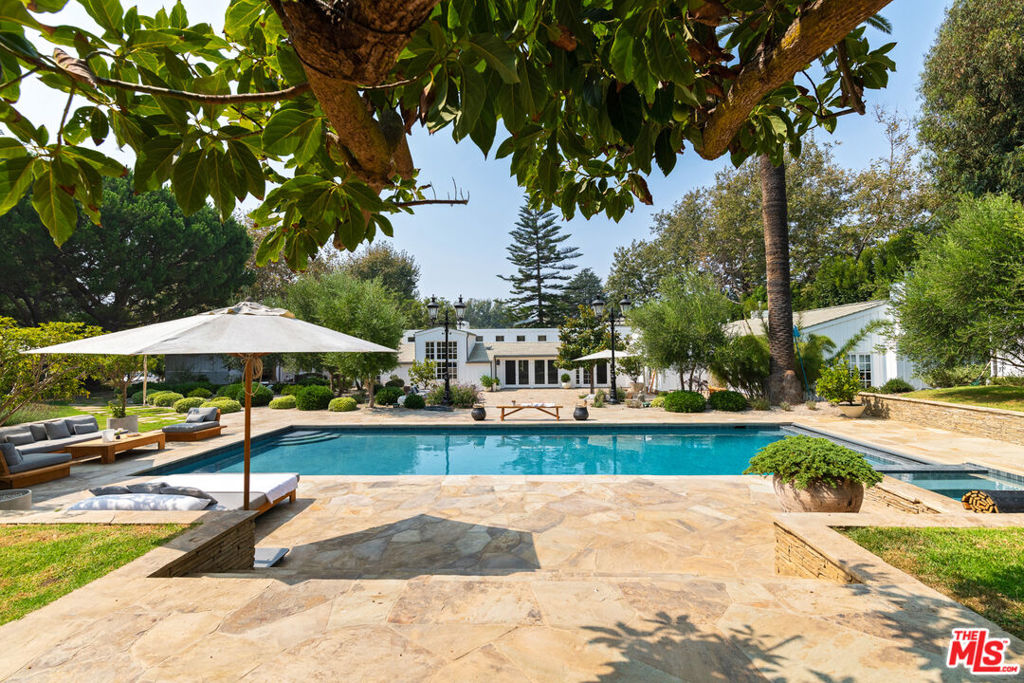 Discover a breathtaking sanctuary minutes from Zuma and Point Dume located on one of Malibu's premiere streets, Bonsall Drive. This 3.8-acre compound, with verdant lawns and magnificent trees, redefines indoor-outdoor living. The main house and two guest houses offer tranquility and sophisticated entertaining. The single-story Cape Cod-style main house features high sloped ceilings, hickory floors, and garden views from every room. The expansive living room, with a fireplace and walls of glass windows, opens to a charming front porch. The dining room leads to a sensational kitchen with an island, marble countertops, Lacanche French ovens, and glass doors to a shaded patio with lounge seating, a firepit, and bbq. Down the hall from the entryway you'll find four en-suite bedrooms, including an expansive primary suite with a fireplace, garden views, and two full baths. Two separate guest houses offer additional living space and privacy. The property includes a pool, spa, stone fireplace, bocce court, treehouse, skateboard bowl, vegetable garden, and chicken coop. This Bonsall Canyon residence embodies comfort and sophistication.