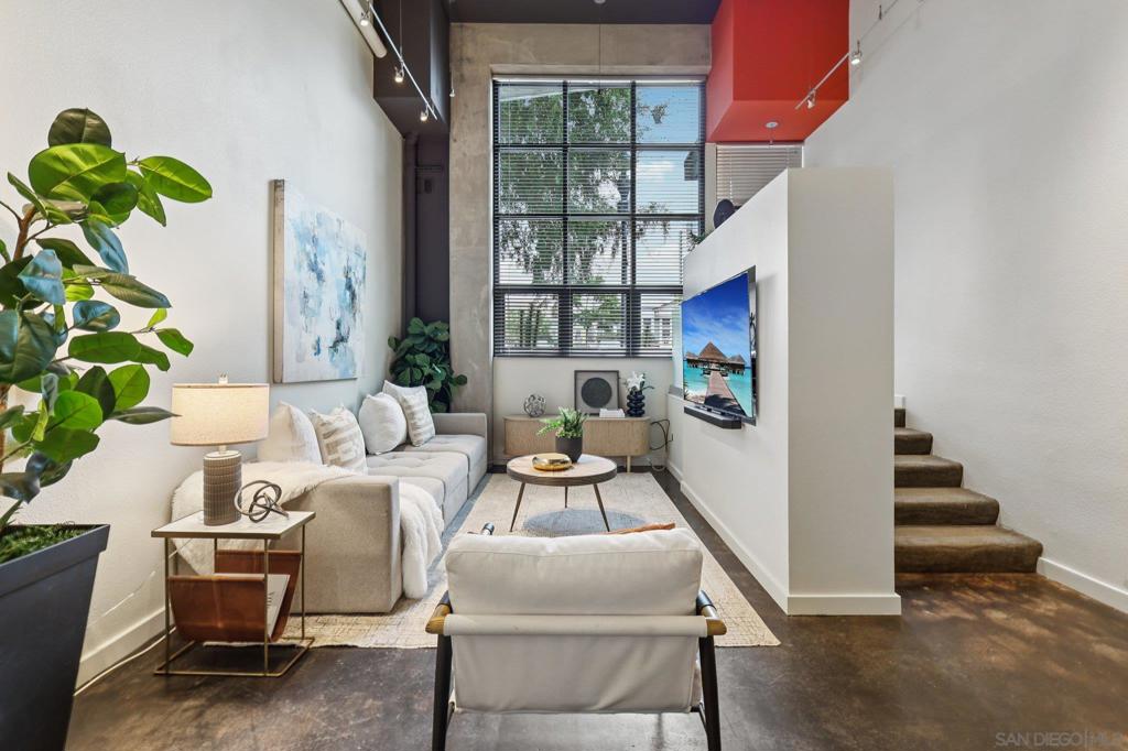 Discover an exceptional opportunity at The Lofts @ 777 Sixth Ave — perfect for office, live/work, or creative use. This corner unit showcases modern industrial design with soaring ceilings and dramatic floor-to-ceiling windows that flood the space with natural light. Enjoy the flexibility of a private street-level entrance on 7th Avenue or entry through the secure common hallway. The open layout offers defined spaces for greeting, conference, and office areas, along with an upstairs loft ideal for additional office space or a bedroom. As a residence, the home features living, dining, and kitchen areas, with plumbing in place to easily add a full kitchen. A spacious bathroom with shower and ample closet space adds convenience. Additional highlights include one secure underground parking space and access to community amenities such as a fitness center and BBQ/entertaining area. Located in the center of Downtown, you’re surrounded by the best of San Diego living — Gaslamp Quarter, East Village, Petco Park, the Rady Shell and strolls along the harbor are right outside your front door, while Little Italy and the airport are just minutes away. With quick freeway access, Balboa Park and the beach communities are within easy reach.