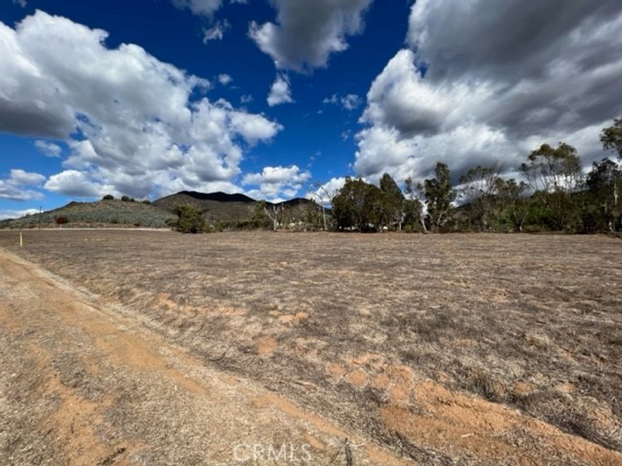 PRIME CORNER LOT WITH TWO PARCELS – Exceptional Location and Endless Possibilities! Nestled in a sought-after area surrounded by luxurious homes and thriving orchards, these two flat corner lots offer incredible potential for your dream home or investment project. The property boasts level terrain with street frontage on two sides, providing unmatched accessibility and flexibility. Gentle topography nice views down the canyon. With two water meters already on each parcels, building or cultivating is made even easier. Whether you envision a residential oasis or an agricultural endeavor, the possibilities are infinite. Easy access to Hwy 15 approximately 4 miles to intersection of Hwy 15 and Hwy 76, about 5 miles to the Pala Casino Spa Resort. Call Today!