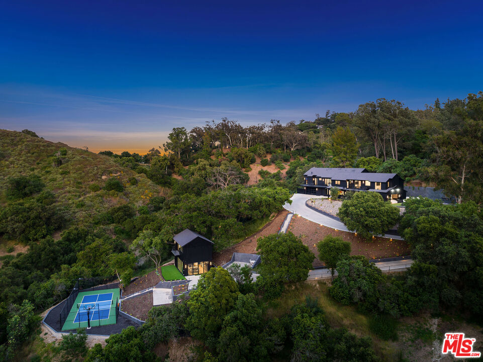 THE ROYAL OAK ESTATE This 4-1/2 acre unique parcel of land features a magnificent residence with guest house on an amazing, private compound surrounded by lush Oaks and beautiful greenery. The private driveway winds 3/4 of a mile off of Coldwater Canyon bringing you to the main house. Over 1000 mature protected Oak trees, roaming indigenous animals, hiking trails, and pristine views of Studio City and the mountains. This impeccably upgraded Farmhouse designed, finished home features 8 LARGE bedrooms, 7 full bathrooms plus 3 powder rooms and incredible amenities. Considered a completely smart home with Lutron automatic controlled lighting, automatic shades, intercom, cameras throughout the property, central music and security - nothing has been missed! Wolf/Subzero appliances in the gourmet kitchen and outdoor kitchen. Chef's paradise includes Miele built in coffee system, 2 dishwashers, massive island with brilliant lighting throughout. Entertaining is a breeze with the indoor-outdoor flow, full wet bar, refrigerated wine cellar and built-ins. White Oak hardwood floors throughout with Italian Porcelain and Quartz countertops exude beauty at every turn. All bedrooms have vaulted ceilings, en-suite baths and walk-in closets. Gorgeous views from the shared balcony for all "kids" bedrooms. An amazing master bedroom with 15' ceilings, private balcony, massive master closet and quintessential master bathroom with a kitchenette, his and hers toilets TOTO washlets top of the line, 100 sq ft master shower impeccably finished! Huge outdoor kitchen, bbq AND firepit with lovely dining area under dual heating elements and a central fan. Sparkling pool and spa with pool cover, waterfall and fire feature and outdoor bathroom and shower. Large back yard overlooking mature vegetation. Host your friends with an official pickleball court with basketball hoop! Fully powered golf carts for easy access across this massive compound. Property houses wild deer, goats, among other natural livestock. The parking garage and spaces to host over 50 cars for entertaining! This property is beautifully manicured with intense landscaping, outdoor lighting. You'll never tire of the beauty, fresh air, and activities at your fingertips. A quick 10-minute drive to Beverly Hills and 8-minute drive to Studio City and shopping.