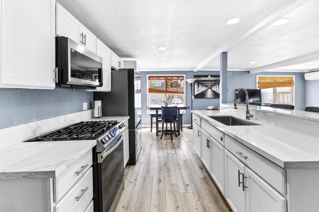 This beautifully renovated home in the ALL-AGES community of Terrace Garden Mobile Estates blends modern style with comfort. The upgraded kitchen boasts stainless steel appliances, sleek white cabinetry, and a farmhouse-style sink. New vinyl plank flooring flows throughout, enhancing the open feel. Both bathrooms have been tastefully remodeled with quartz countertops and white vanities. The spacious primary bedroom provides dual closets for ample storage. Outside, enjoy a large patio—perfect for relaxing or entertaining. Low space rent. Community amenities include clubhouse and pool.