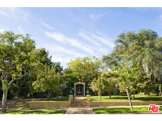 A PRIVATE & SEQUESTERED RALPH FLEWELLING AIA, COURTYARD SPANISH. 1929 walled & gated villa has all the classic elements of a pure & timeless Beverly Hills Estate. Featuring a dramatic living room with stone fireplace & high beamed ceilings, Library with fireplace, formal dining w/ beamedceilings, kitchen adjacent to family room along w/ junior dining room, Master bedroom has a FP, patio, and a huge ensuite bath & closet. 2 additional bedroom suites up - maids/office down, Outdoor dining area & living room complete with fireplace and built-in banquets, exterior kitchen/bar area, lap pool, spa and 2 fully self contained guest houses Double garage w/ adjacent gated carport. So much to this property one has to see to fully experience. All principle rooms, both front and back access the gorgeous gardens, This a well scaled house that was updated & expanded in the early 1990's - it's time for another, but perfect for those looking to create their own world w/ ultimate privacy & location.