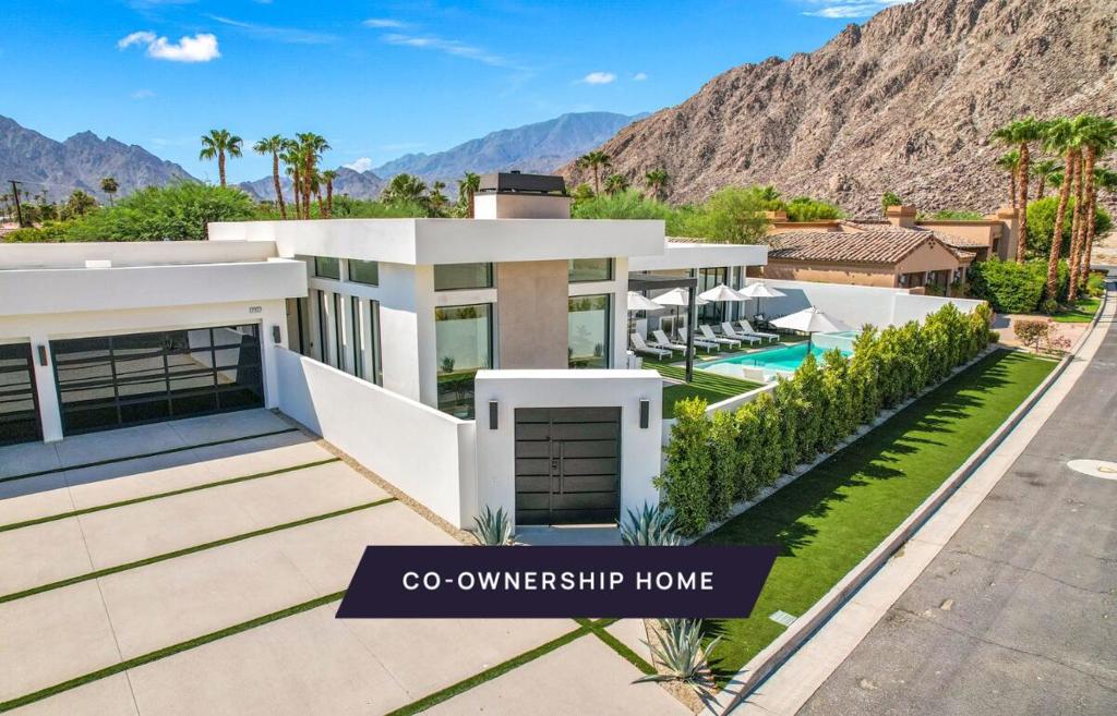 New co-ownership opportunity: Own one-eighth of this professionally managed, turnkey home. Nestled in the mountains within the private enclave of Flores Montanas, this modern new-construction residence offers a walled courtyard that enhances privacy. Each of the four bedrooms includes its own en suite bathroom for comfort and convenience.Enter through the gate to find two in-ground fire features set in a low-maintenance turf lawn, surrounded by thoughtfully designed landscaping. The custom glass front door opens to an airy, open-plan living space with 14-foot ceilings, plank tile floors, Cambria quartz counters, gold-toned fixtures, and custom lighting. Multiple La Cantina pocket doors create a seamless indoor/outdoor flow.The zero-edge pool with custom tile work and large Baja shelf provides an inviting space to take in the mountain views. Two BBQ counters and a fire pit are positioned just outside the primary bedroom. The primary suite includes a dressing area and soaking tub.Additional highlights include a flexible workspace/media station in the hall, a butler's pantry/laundry area with barn door, a coffee bar, and floating shelves. The home comes fully furnished and professionally decorated.