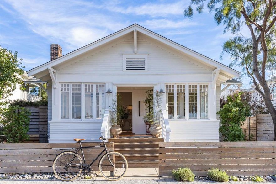 This soulful jewel box w/ historic cred & vintage charm is Front & Center to Cardiff’s beachy-urban lifestyle. Ocean views, sunset moments & a legendary origin story, this 1912 Craftsman was home to Composer District developer who famously affixed “by-the-Sea” to Cardiff. Impeccably preserved, the 3BD, 2BA, 1,943SF property beams w/nostalgia: OG wood floors, redwood siding & enclosed Sun Porch w/ocean views. Plus: 2-car garage & outdoor shower. Walk everywhere! Beaches, market, eateries & Rail Trail.  Hands down, this is the most treasured property in Cardiff’s Composer District.  Architectural details are impeccably maintained while a light-filled modern Studio brings a fresh extension of the design. A rich material palette unfolds throughout.   Inside, afternoon sun filters through heritage windows onto wood floors, imbuing a striking sense of history. The Craftsman is warmly anchored in Cardiff legacy. The entry sets the tone to connect with nature, and the neighborhood.   Fling open the Sun Porch windows to ocean views and nightly sunsets. Outside, a vibrant community portrait unfolds. Ignite the backyard fire pit for dinner parties and cocktail hour. Inside, the living room features an original wood-burning fireplace. Another beach-house bonafide? The outdoor shower.   Throughout the house, discover peek-a-boo ocean views in the kitchen, the loft, and the Studio balcony. Everyday is a Cardiff postcard.   Hard to beat this backstory. The original owner who built the house was Victor Kremer—a German music publisher-turned-developer of the Composer District. Envisioning an artists’ colony, Kremer named the streets after his favorite composers like Mozart, Verdi and Rubenstein. Most impressively, he affixed “by-the-Sea” to Cardiff,” taken from the 1914 song “By the Beautiful Sea.”   Today, Cardiff remains one of North County’s in-demand neighborhoods while the Composer District is prized for its architectural diversity. The allure: connectivity, walkability and a fit, active lifestyle. Everything is a quick jaunt: The library, post office, Seaside Market, Waverly restaurant, VGs donuts, coffee shops, schools and internationally acclaimed surf spots.   A hop-skip from Mozart is the Cardiff Rail Trail, buzzing with families, joggers and dog walkers. The safe path connects to the beach and downtown Encinitas. Across the street, there’s more space to frolic; the Cardiff Elementary School (K-2) transforms into a public park after school and on weekends.