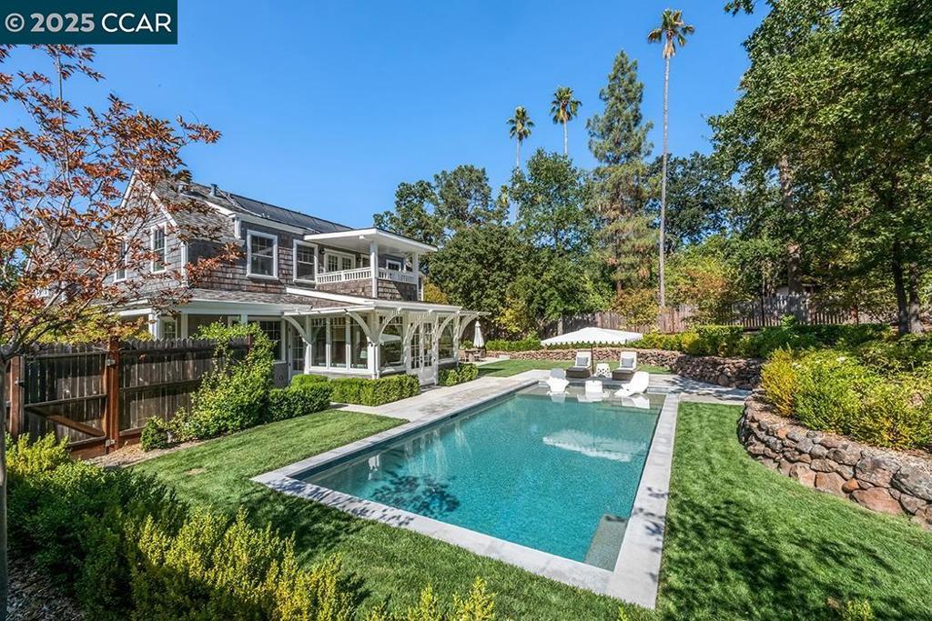 Escape to your own private resort in Walnut Creek's coveted Rudgear neighborhood! This stunning custom home showcases a breathtaking backyard oasis featuring a new pool added in 2024, expansive lawns, multiple entertaining patios, mature oak trees, and an oversized spa—all set on a .69± acre lot that defines resort-style living. Inspired by classic Nantucket architecture, this exceptional property blends luxury outdoor living with sophisticated suburban ease. Inside, discover exceptional finishes including Visual Comfort Lighting, Emtek hardware, and Serena & Lily wallpaper throughout. The thoughtfully designed floor plan features cozy nooks and custom built-ins perfect for both family gatherings and entertaining. The open-concept great room flows seamlessly into casual dining and a stunning kitchen with honed marble counters, Sub-Zero/Wolf appliances, an oversized pantry, and custom cabinetry. The beloved sunroom creates effortless indoor/outdoor living, extending your entertaining space to the resort-style grounds. Guests are welcomed through a crescent driveway to a covered porch, with additional side parking and a spacious 2-car garage. The Rudgear neighborhood is prized for its convenient access to Highways 680/24, and downtown Walnut Creek.