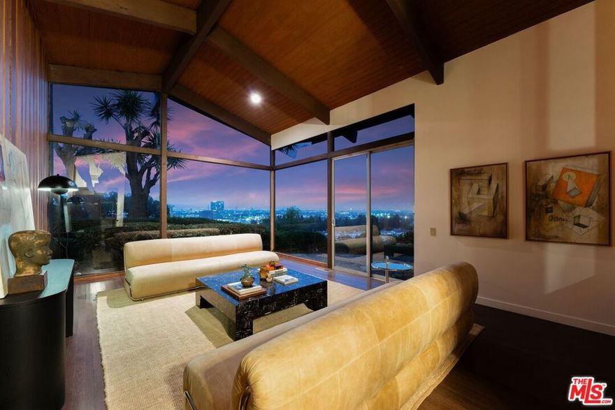 Perched on a private street off Wrightcrest Drive, this sophisticated mid-century gem is suspended over the city with breath-taking panoramic Los Angeles views from every window. The dramatic living room has vaulted ceilings with a two story picture window framing a view from downtown Los Angeles to the Griffith Observatory and Hollywood Hills. Prepare to be wowed. This L-shaped gem wraps around a lush landscaped backyard featuring a renovated salt-water pool, fire-pit, and a bonus side yard with a sitting area which offers a stunning pinpoint view of Downtown LA, as if it was designed solely for this perspective, perfect for your morning coffee or sunset gatherings. Timeless MCM details include; seamless indoor-outdoor flow, natural wood accents, expansive windows merging home with nature, vaulted ceilings in the living/family rooms, skylights bathing spaces with light, and original built-ins exuding era-defining charm. There are 4 bedrooms including a charming Jack-and-Jill (one large bedroom or two separate), luxurious primary en-suite with walk-in closet, and versatile office/guest room. Some modern upgrades include new plumbing, fully paid solar panels, dual-zoned HVAC system, gleaming hardwood floors, fresh fencing, revamped salt-water pool, and fire pit. Preserved original details meets modern comforts and all in Culver City Award Winning School District and Culver City Services! Blair Hills Park is at the end of the private drive and across Wrightcrest Drive, its blocks from the Stoneview Nature Center, across a footbridge from the massive Kenneth Hahn Park, close to the Baldwin Scenic Overlook, and easy access to the Park to Playa trail. Close to the new Whole Foods, Erewhon Market, The Culver Steps, Overlook, Platform, Downtown Culver City, Amazon, Apple, HBO, Sony and central to all Los Angeles has to offer! Come experience 5961 Wrightcrest Drive, a unique opportunity to own a once in a lifetime property.