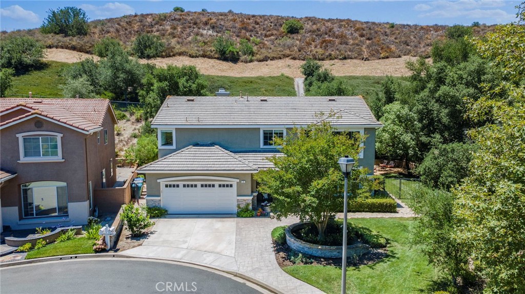 Welcome to your dream home in a serene gated community of Stonecliffe! Nestled on a rare, almost 12,000 sq ft park-like lot, a beautifully updated 4-bedroom house with a large open loft, 2.5 bathrooms & a 3-car tandem attached garage, offers the perfect blend of luxury, space, and privacy. With only one neighbor and no one behind, enjoy peaceful living and picturesque views from nearly every window.
Situated on a cul-de-sac street with an incredible & expansive yard, framed by mature trees, as well as a lemon & avocado tree which provides both beauty and privacy, the covered front porch exudes charm & would be a great place to sit while children or pets play.
Once you enter through the fabulous Dutch door, you’ll find soaring high ceilings, crown molding, plantation shutters, and beautiful yet low-maintenance porcelain wood-look floors. The open and versatile floor plan is ideal for entertaining, featuring a gorgeous, remodeled kitchen with quartz countertops and cabinetry that extends to the ceiling, a cozy fireplace, ceiling fans, newer A/C & Tesla-leased solar. All bathrooms have been thoughtfully renovated, including dual sinks, walk-in showers, and a soaking tub.
Upstairs, a convenient laundry room with extra linen storage, generous-sized bedrooms, and a large open loft. The three-car tandem garage provides ample space for vehicles and storage, making this floor plan incredibly versatile.
Step outside and fall in love with the expansive, private backyard — an entertainer’s dream with a built-in BBQ, 2-burner range & a large covered aluminawood patio cover, with enough space for a pool and an ADU! This home truly has it all.
Don’t miss your opportunity to own this private oasis with luxury finishes and room to grow!