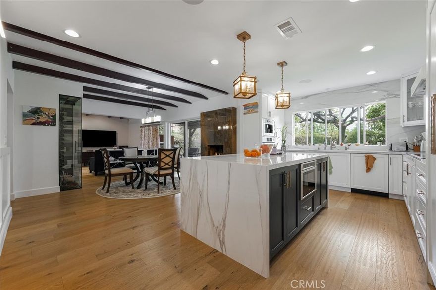 Welcome to this stunning Mid-Century gem, thoughtfully updated to blend timeless character with modern comfort. With 3 bedrooms, 2 bathrooms, and approximately 2,025 sq. ft. of inviting living space, this home features an open floor plan that’s perfect for both everyday living and entertaining.
Step inside to a bright, welcoming foyer that flows into a spacious living room with a cozy fireplace—an ideal spot to relax and unwind. The formal dining room, also with its own fireplace, connects seamlessly to the beautifully designed chef’s kitchen, which showcases quartz countertops, custom cabinetry, and premium Bosch appliances including a stove, oven, microwave, dishwasher, refrigerator, and built-in coffee machine. Hardwood floors, custom woodwork, and exposed beam ceilings give this home its unique warmth and charm.
The primary suite is a true retreat, offering built-in closets, a spa-like soaking tub, a separate shower, and direct access to a private slate patio—perfect for enjoying a quiet cup of coffee or the evening breeze.
The backyard is designed for gathering and entertaining, with a covered patio, ceiling fans, a built-in BBQ, and a fire pit for year-round enjoyment. The 8,050 sq. ft. lot features mature landscaping, a garden shed, and RV parking with hookups for added flexibility.
Additional upgrades include a video surveillance system, EV charger, surround sound, water softener and filtration system, central air, and built-in speakers throughout the home.
Located in one of Burbank’s most desirable neighborhoods, this home offers the perfect blend of comfort, style, and convenience—close to Disney, Warner Bros., and Netflix studios, as well as top-rated schools, parks, shopping, and dining. A truly special home ready for its next chapter.