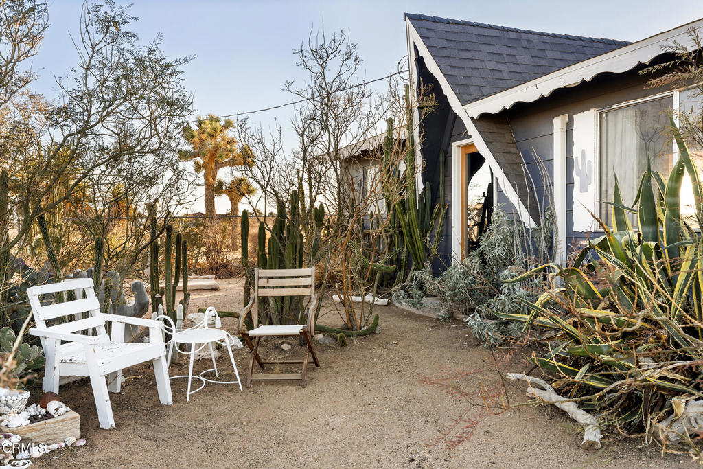 Welcome to 1624 Balsa Ave--a one-of-a-kind creative retreat, owned and updated by an artist and interior decorator. This stylish two-bedroom, one-bath home perfectly balances comfort and character. The open living space is bathed in natural light and features a charming wood-burning fireplace, custom maple cabinetry, and a stunning glass door with screened sidelights that lead to a serene back patio. Rustic concrete floors and custom woodwork throughout the home add warmth and a distinct desert vibe. The remodeled bathroom is a showstopper, with hand-applied silver-leafed walls, a spacious walk-in shower, and a rare vintage Kohler sink paired with a Waterworks faucet. Solar panels help keep utility costs low, while a newer mini-split system and vintage maple ceiling fans in every room ensure year-round comfort. Additional upgrades include a new 200-amp electrical panel and a recently replaced roof. Set on 2.5 acres of natural beauty, the property offers a sanctuary-like environment where you can observe indigenous wildlife, including quail, rabbits, and birds, amidst mature landscaping, white sage plants, and vibrant birds-of-paradise trees. The property also boasts a cedar hot tub for soaking up the breathtaking sunsets, a two-car detached garage, and a 40-ft shipping container for storage or creative projects. Partially furnished and ready to inspire, this thoughtfully designed desert gem is waiting to welcome you home.