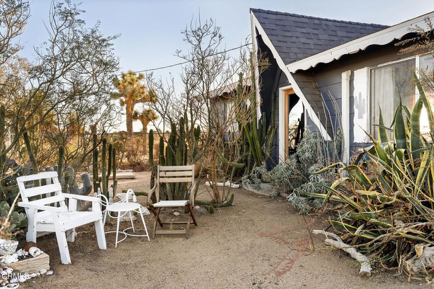 Welcome to 1624 Balsa Ave--a one-of-a-kind creative retreat, owned and updated by an artist and interior decorator. This stylish two-bedroom, one-bath home perfectly balances comfort and character. The open living space is bathed in natural light and features a charming wood-burning fireplace, custom maple cabinetry, and a stunning glass door with screened sidelights that lead to a serene back patio. Rustic concrete floors and custom woodwork throughout the home add warmth and a distinct desert vibe. The remodeled bathroom is a showstopper, with hand-applied silver-leafed walls, a spacious walk-in shower, and a rare vintage Kohler sink paired with a Waterworks faucet. Solar panels help keep utility costs low, while a newer mini-split system and vintage maple ceiling fans in every room ensure year-round comfort. Additional upgrades include a new 200-amp electrical panel and a recently replaced roof. Set on 2.5 acres of natural beauty, the property offers a sanctuary-like environment where you can observe indigenous wildlife, including quail, rabbits, and birds, amidst mature landscaping, white sage plants, and vibrant birds-of-paradise trees. The property also boasts a cedar hot tub for soaking up the breathtaking sunsets, a two-car detached garage, and a 40-ft shipping container for storage or creative projects. Partially furnished and ready to inspire, this thoughtfully designed desert gem is waiting to welcome you home.