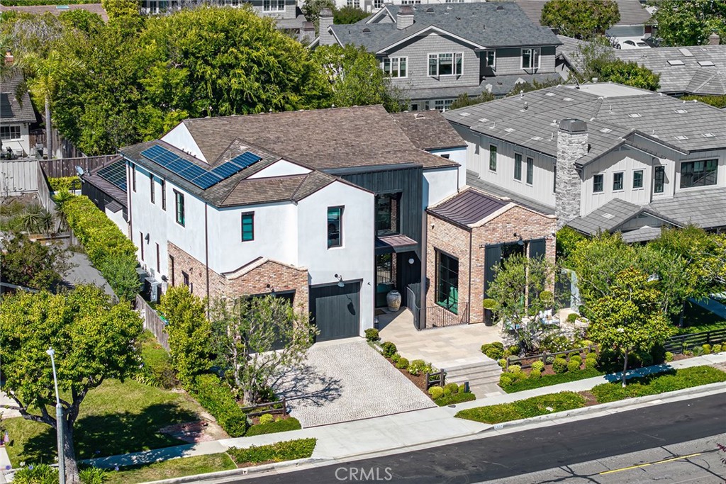 Set on an expansive lot in the coveted Port Streets community, this exceptional custom estate offers nearly 6,000 square feet of refined living space designed for comfort, style, and effortless entertaining. From the dramatic entry with soaring ceilings to the meticulous detailing throughout, every element of the home reflects a harmonious blend of sophistication and warmth. At the heart of the home, a true chef’s kitchen is equipped with premier Wolf and Sub-Zero appliances, a built-in Miele coffee station, dishwasher, a generous center island with seating, and a walk-in pantry. A retractable serving window connects the kitchen to an outdoor loggia and built-in barbecue, creating an ideal setup for indoor-outdoor gatherings. Just off the kitchen, the inviting family room showcases a fireplace, custom beamed ceilings, and a full wall of retractable glass doors that open to the spectacular backyard retreat. Designed to maximize year-round enjoyment, the private yard features a covered California room with fireplace, ceiling heaters, built-in BBQ, outdoor refrigeration, and a curated chandelier that enhances the ambiance. The pool and spa are complemented by a stylish casita with retractable doors, custom cabinetry, television, and a dedicated pool bath. A lounge area and grassy play space complete the outdoor experience. Inside, the main level also includes a spacious private office with custom cabinetry and serene patio views. On the lower level, a sprawling entertainment hub awaits with a secondary family room featuring three televisions, a lounge area, space for gaming or a pool table, and a striking custom bar with island seating, beverage fridge, dishwasher, and a temperature controlled wine cellar. Adjacent is a professional-grade gym , UV sauna and cold plunge - the true definition of a home health environment. Upstairs, the sunlit primary suite provides a luxurious retreat with marble-clad bath, soaking tub, walk-in shower, and a generous custom closet. Three additional guest bedrooms, two bathrooms, a cozy study nook, and a well-appointed laundry room complete the upper level. Additional features include solar panels, Control4 smart home automation, water filtration, an outdoor shower, a spacious side yard with dog run, and a finished two-car garage with built-in storage. This thoughtfully designed residence presents an extraordinary opportunity to enjoy the very best of Newport Beach living.