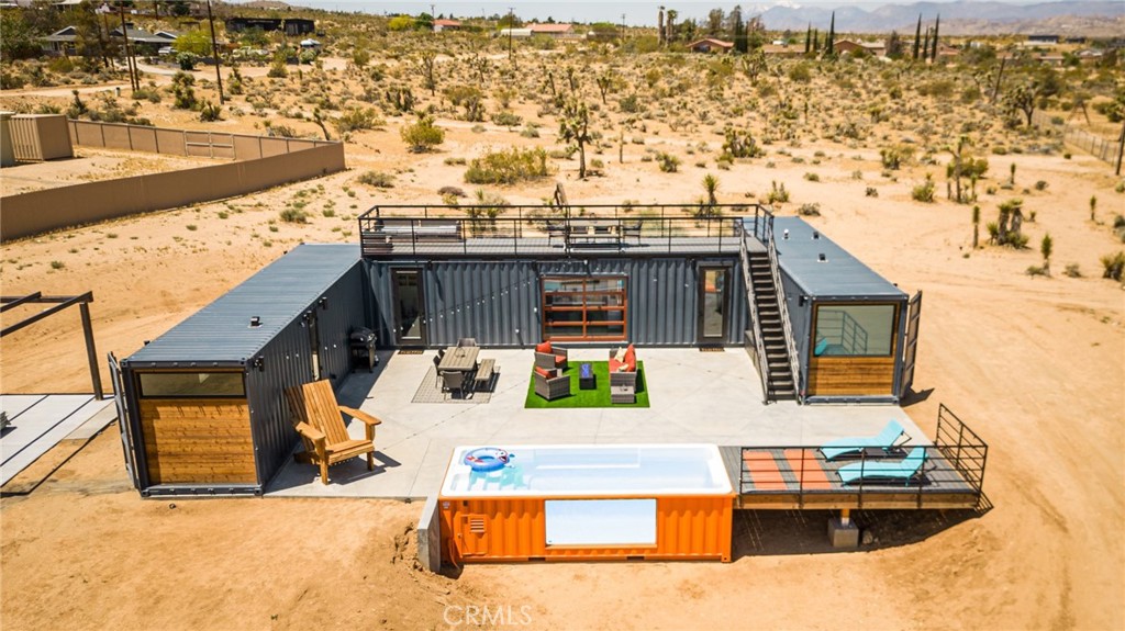 Welcome to 6816 Saddleback Rd, AKA Box on the Rox! A truly unique & ONE-OF-A-KIND fully-permitted Container POOL home located in the highly desirable town of Joshua Tree. This property is nicely situated on 1.25 acres of prime land complete with stunning desert & mountain views and is just minutes from downtown, the park entrance, shops, galleries, eateries & more. This 3 bedroom, 2 bath contemporary home was designed by renowned architect David Bailey and was built in 2022 with every feature intentionally chosen to bring you the perfect desert home, airbnb or weekend retreat. Complete with PAID SOLAR, 5 mini-splits (to keep you comfortable year round), a full size stackable washer & dryer, a large carport, EV Charger & a Fully Furnished Roof Top Deck! The kitchen includes full size stainless steel appliances & dining can be enjoyed both inside & out, compliments of the modern, electric roll-up door. The primary bedroom features an ensuite spa-like bathroom with 2 single sink vanities, an oversized walk-in shower with 2 rainfall shower-heads and a soaking tub for full relaxation. The additional bathroom also adorns a walk-in shower with a rainfall shower-head and all 3 bedrooms include queen size memory-foam mattresses and picture windows that let in an abundance of natural light. Outside is truly an entertainers dream, from the private Roof Top Deck to the awe-inspiring Pool (which can be adjusted to also be used as a hot-rub), it's truly the perfect place to unwind in nature but with the added bonus of modern comfort and convenience. This home is also being sold Fully Furnished! A property like this rarely becomes available, come take a look & let it's charming allure do the rest. Your new desert home, investment property or weekend retreat awaits!