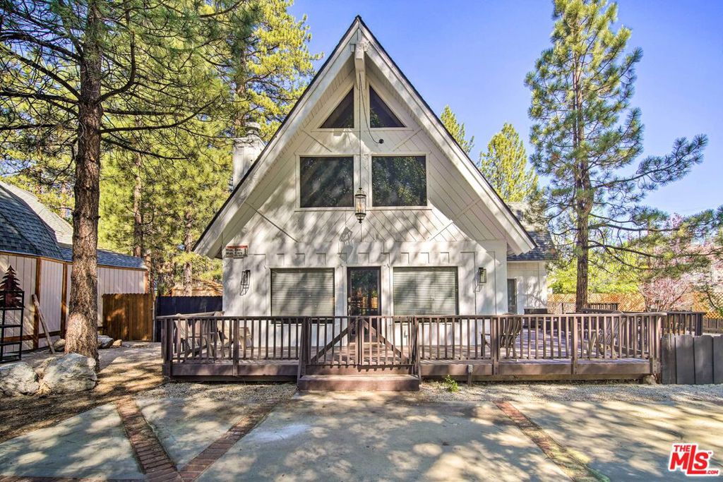 Welcome to your mountain getaway! This beautifully maintained A-Frame home offers the perfect blend of cozy charm and modern comfort. Nestled among the pines in scenic Big Bear, this 3-bedroom, 2-bathroom retreat spans 1,607 square feet and is the ideal home base for year-round adventure. Step inside to soaring vaulted ceilings, a dramatic wall of windows that flood the space with natural light, and an inviting open-concept layout. The living area features a wood-burning fireplace for those snowy winter nights, while the spacious kitchen opens seamlessly to the dining area perfect for entertaining or family gatherings. Enjoy two bedrooms on the main level plus a full bath, while the upstairs primary suite offers added privacy with its own bath and loft-style views of the living space below. Outside, the expansive deck is perfect for sipping morning coffee, grilling with friends, or stargazing after a day on the slopes or lake. Whether you're looking for a full-time residence, a weekend escape, or a turn-key short-term rental investment, this A-Frame delivers classic mountain vibes with all the amenities of home. With Big Bear Lake, ski resorts, hiking trails, and the Village just minutes away, this home checks all the boxes for lifestyle, comfort, and income potential. Please note this is a short sale