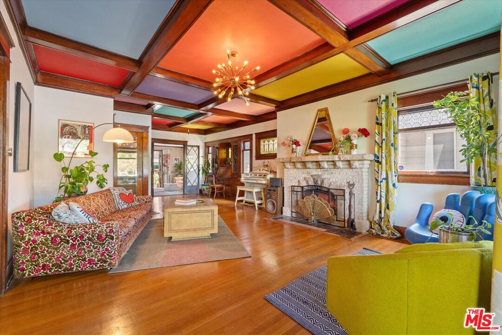 Step into a harmonious blend of timeless craftsmanship and bohemian elegance at 1654 5th Ave, a 1911-built Craftsman three bed two bath masterpiece nestled in the heart of Arlington Heights. This almost 2,000 sq ft home sits on a generous 7,000 sq ft lot and exudes character at every turn, with original box beam ceilings, richly polished hardwood floors, an elegant stairway, and expertly milled built-ins offering both beauty and abundant storage. Bathed in natural light, the home's inviting spaces are accented by stained glass and a custom fireplace, while the formal dining room sets the stage for memorable gatherings. Outdoors, the lower deck is perfect for alfresco dining, while the rare rooftop deck captures sweeping panoramic views and the area's delightful afternoon breeze. Surrounded by a professionally landscaped garden blooming with fruit trees and flowering plants, the home offers a serene escape from city life. A gourmet kitchen with granite countertops and stainless steel range, central heat and AC, a two-car detached garage, and ample driveway complete this soulful sanctuary that artfully marries classic craftsman design with creative expression in one of Los Angeles' most centrally located, vibrant neighborhoods.