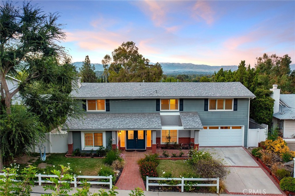 Walnut Acres upgraded pool home located on a quiet cul-de-sac with rare Valley and mountain views! The front yard features great curb appeal with white picket fencing, grass lawn, covered front porch, and driveway that leads to the 2-car garage with direct access. Step into the formal entry to find a light and bright floor plan with wide plank flooring found throughout. The family room features stacked stone fireplace with new accent wall, wood beamed ceiling, and large picture windows with plantation shutters. The formal dining room has direct kitchen access and a large glass slider that opens to the backyard. The remodeled kitchen overlooks the pool and Valley vistas boasting quartz counters with tile backsplash, stainless appliances including Frigidaire 5-burner stovetop and oven, warming drawer, and pantry storage. There is a separate den/bonus room with large picture windows. The first level also has a remodeled guest powder bath with newer vanity and subway tile backsplash; a laundry room with storage cabinets; and another remodeled pool bathroom with updated vanity, tile backsplash, and walk-in shower. Upstairs you will find four bedrooms and two additional bathrooms. The massive oversized primary suite features balcony deck overlooking the grounds perfect for taking in the amazing Valley views, large walk-in closet, and private remodeled en-suite bathroom with dual sinks and large walk-in shower. The three secondary bedrooms are all large sized featuring spacious closets. An upgraded hall bathroom has dual sinks, bathtub, and shower with glass tiling. The entertainer’s backyard boasts a large swimming pool, two covered pergolas for outdoor dining, plus large deck perfect for taking in the stunning Valley, mountain, and city light views! Adjacent to dining/shopping at the Westfield Mall/Village, The Calabasas Commons, & zoned for award-winning El Camino & Hale charter schools.