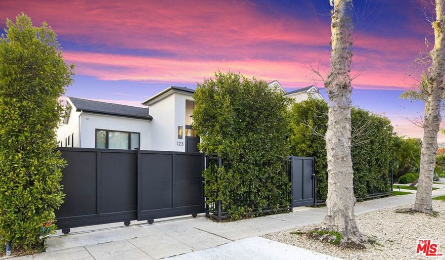 Exceptional value in this newer-construction modern farmhouse with a permitted ADU featuring its own address and entrance. Experience the best of Beverly Grove living from this perfectly situated compound on one of Beverly Grove's most walkable and picturesque streets. This single-story smart home offers rare privacy and effortless sophistication. Behind tall hedges and secure gates, natural light fills open, airy entry and living room highlighted by dramatic floor to ceiling fireplace. Wide-plank white oak flooring, high ceilings, and designer details throughout. The dining room connects to the living room providing the perfect size for hosting friends and family. The chef's kitchen centers on a dramatic 12-foot marble waterfall island, custom cabinetry, and high-end appliances which open to the family room featuring floor-to-ceiling fireplace, an abundance of custom built-ins, wine rack, LED-lit display shelves, as well as wall accent design features. The extraordinary flow of the open kitchen and family room transitions smoothly into the resort-style backyard with pool, spa, elevated deck for seating or dining area plus grassy lounge area. The serene primary retreat offers privacy away from the main living areas and bedrooms along with sliding doors to a private outdoor seating area. The primary also includes two LED-lit walk-in closets, a spa-inspired 2-person shower with bench and dual vanities. Two additional bedrooms share a thoughtfully designed connecting full bath, offering comfort and convenience. There is also a striking powder room off the main living areas. A California basement gives additional storage. The detached ADU with kitchenette and bath provides flexible living ideal for guests, an office, gym, or creative studio. Designed and built in 2022, this home delivers a refined, move-in-ready lifestyle just moments from The Grove, Beverly Hills, and LA's best dining and shopping. *more photos coming soon*