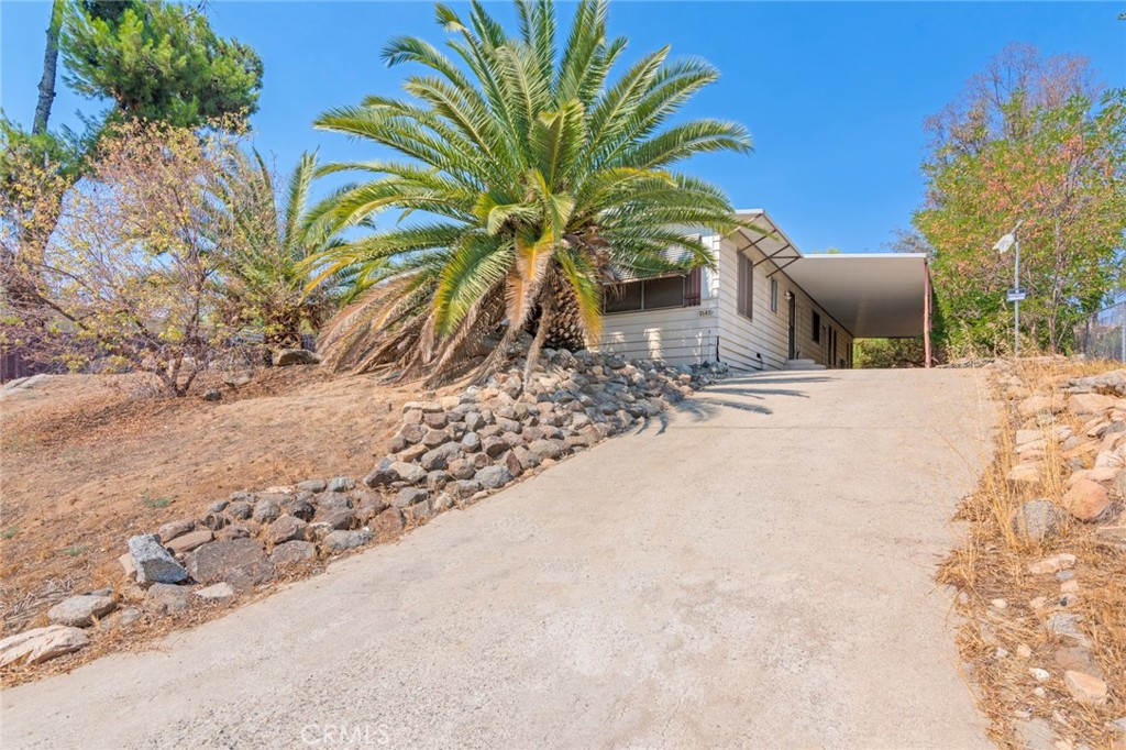 Spacious 3 bedroom, 2 bath manufactured home on its own land in Gavilan Hills! Offering 1,660 sq ft of living space on a 1/3 of an acre lot, this single-story home features an open floor plan, newer vinyl wood flooring, and a bright living room that flows into the dining and kitchen areas. The kitchen offers plenty of cabinet space, gas range, and a separate laundry room. The large primary suite includes dual sinks, soaking tub, and walk-in shower. Secondary bedrooms are generously sized. Outside, enjoy a fenced backyard, hillside views, and a huge covered carport running the length of the home, perfect for multiple vehicles, RV, or toys. Quiet rural setting, yet close to Cajalco Rd, shopping, schools, and freeway access. No HOA, low taxes, and room to create your ideal outdoor space. This home does NOT qualify for traditional financing (NO FHA, VA, USDA or CONVENTIONAL) due to the age.