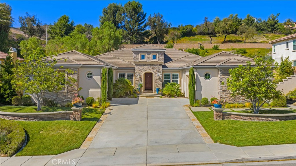 A Toll Brothers single-story luxury home situated in a tranquil community in the heart of Yorba Linda. The impressive great room features an entertainment bar, fireplace, and an expansive open-concept design. The upgraded chef’s kitchen is ideal for hosting, with a large central island, six-burner cooktop, double oven, oversized refrigerator/freezer, and walk-in pantry. The primary suite includes a fireplace flanked by custom built-in cabinetry, a stone-accented en-suite bathroom with dual vanities, a separate soaking tub, and a walk-in shower. The office with custom cabinetry is conveniently located near the entrance. A separate wing offers two en-suite bedrooms, an open media room, and a spacious laundry area, completing the main residence. An attached guest casita with a living area, full bathroom, and walk-in closet provides an excellent space for visitors or a home theater. The highly-rated school district, with a 9-9-9 rating, is just 0.6 miles from Yorba Linda High School.